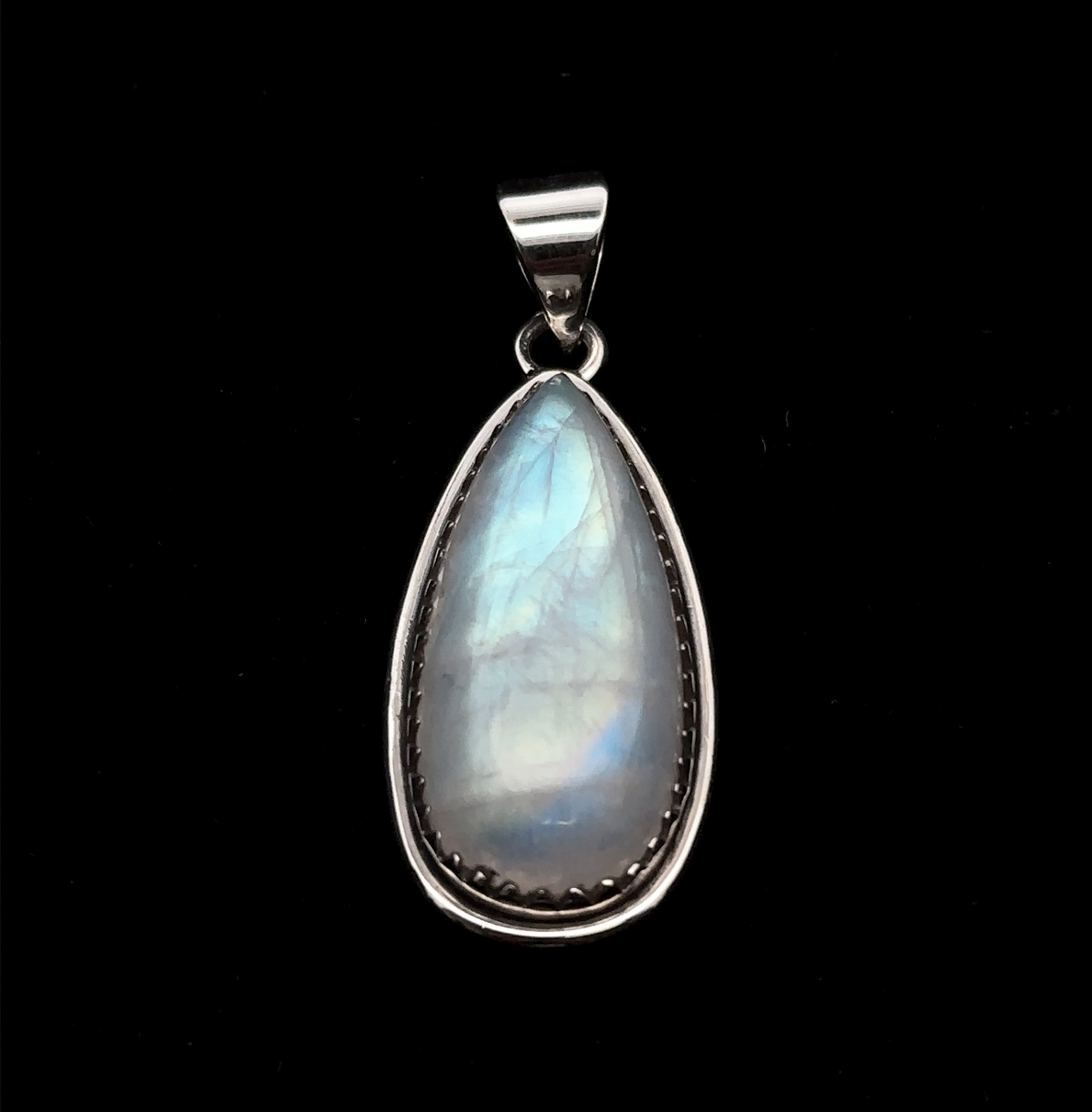 The Teardrop Moonstone Pendant features a moonstone in a teardrop shape set in sterling silver with a matching bail, shown against a black background.