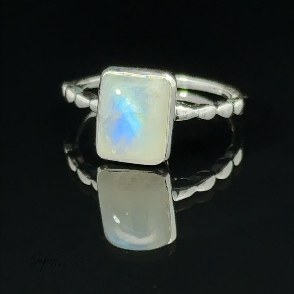 
                  
                    Rectangle Gemstone Ring with Beaded Band with a classic rectangular opal set on a reflective surface, featuring a subtle blue glow, with the word "supersilver" inscribed in the corner.
                  
                