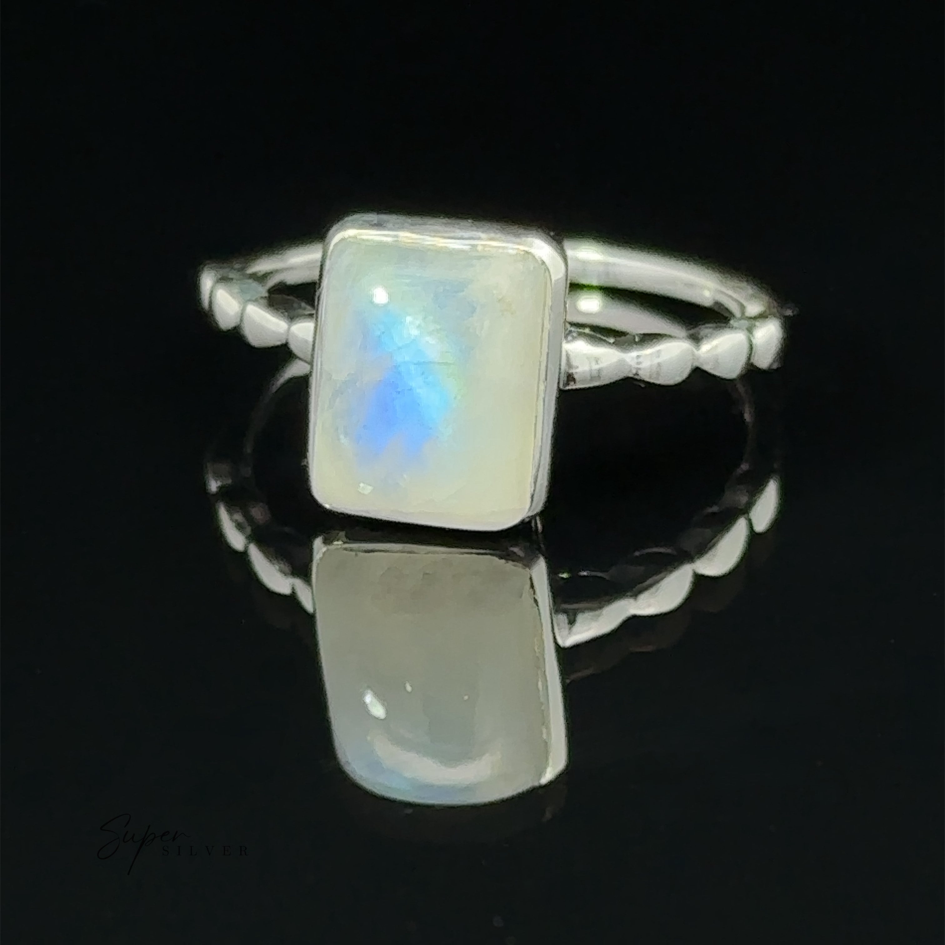 Rectangle Gemstone Ring with Beaded Band with a classic rectangular opal set on a reflective surface, featuring a subtle blue glow, with the word "supersilver" inscribed in the corner.