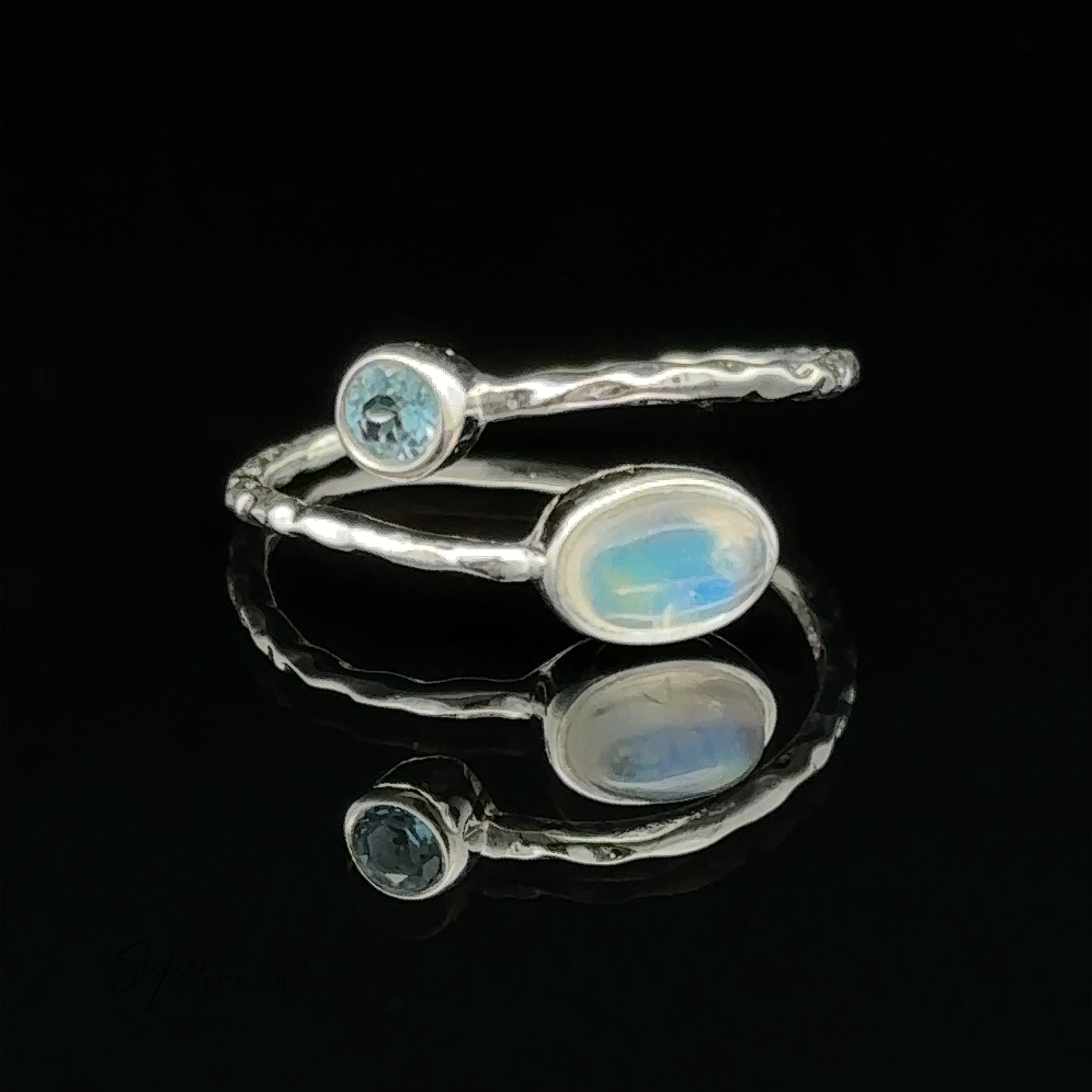 Textured Adjustable Band with Adorned Gemstones with a blue topaz and an opal gemstone on a reflective surface against a black background.