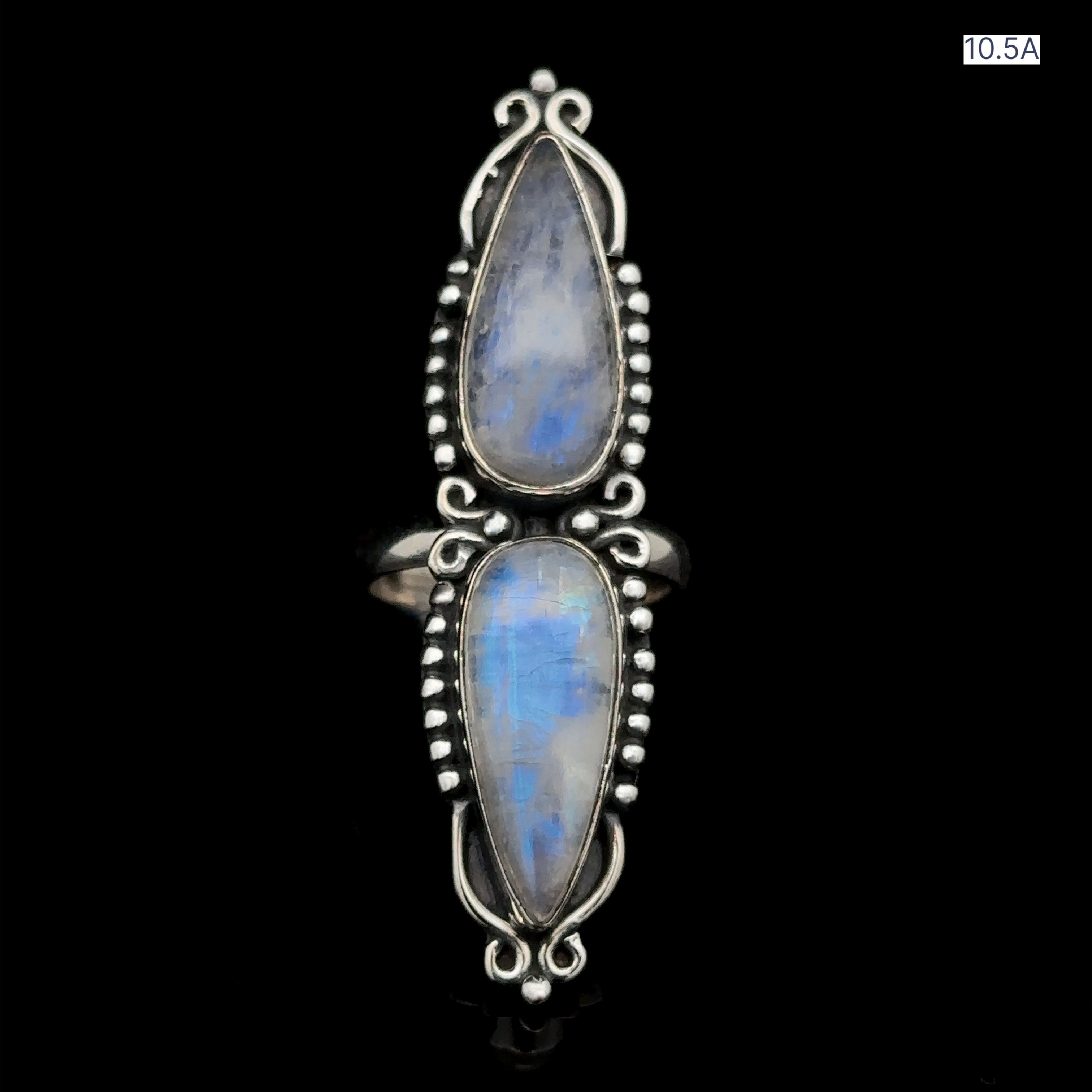 The Long Double Teardrop Moonstone Ring, crafted from sterling silver, showcases two vertically aligned teardrop-shaped moonstones with intricate metalwork detailing, all set against a black background, making it the perfect statement ring.