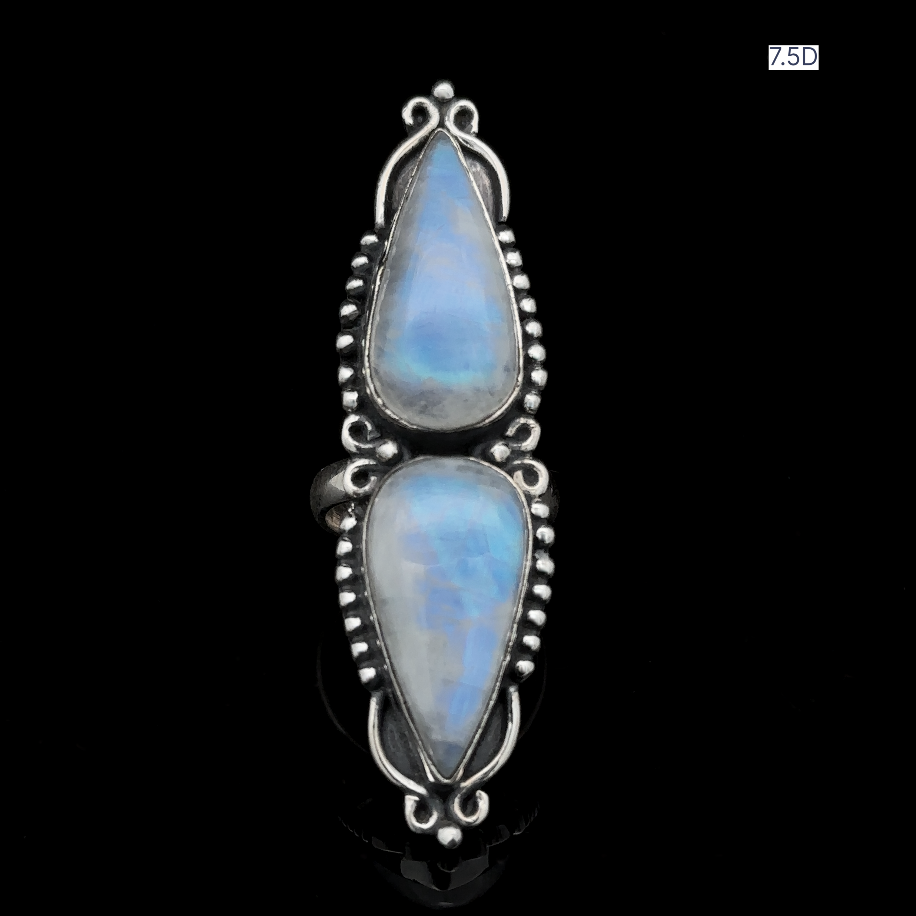Introducing the Long Double Teardrop Moonstone Ring—a stunning sterling silver ring showcasing two pear-shaped moonstone gems set vertically against a black backdrop, making it a striking statement piece. The size notation "7.5D" is visible in the top right corner.