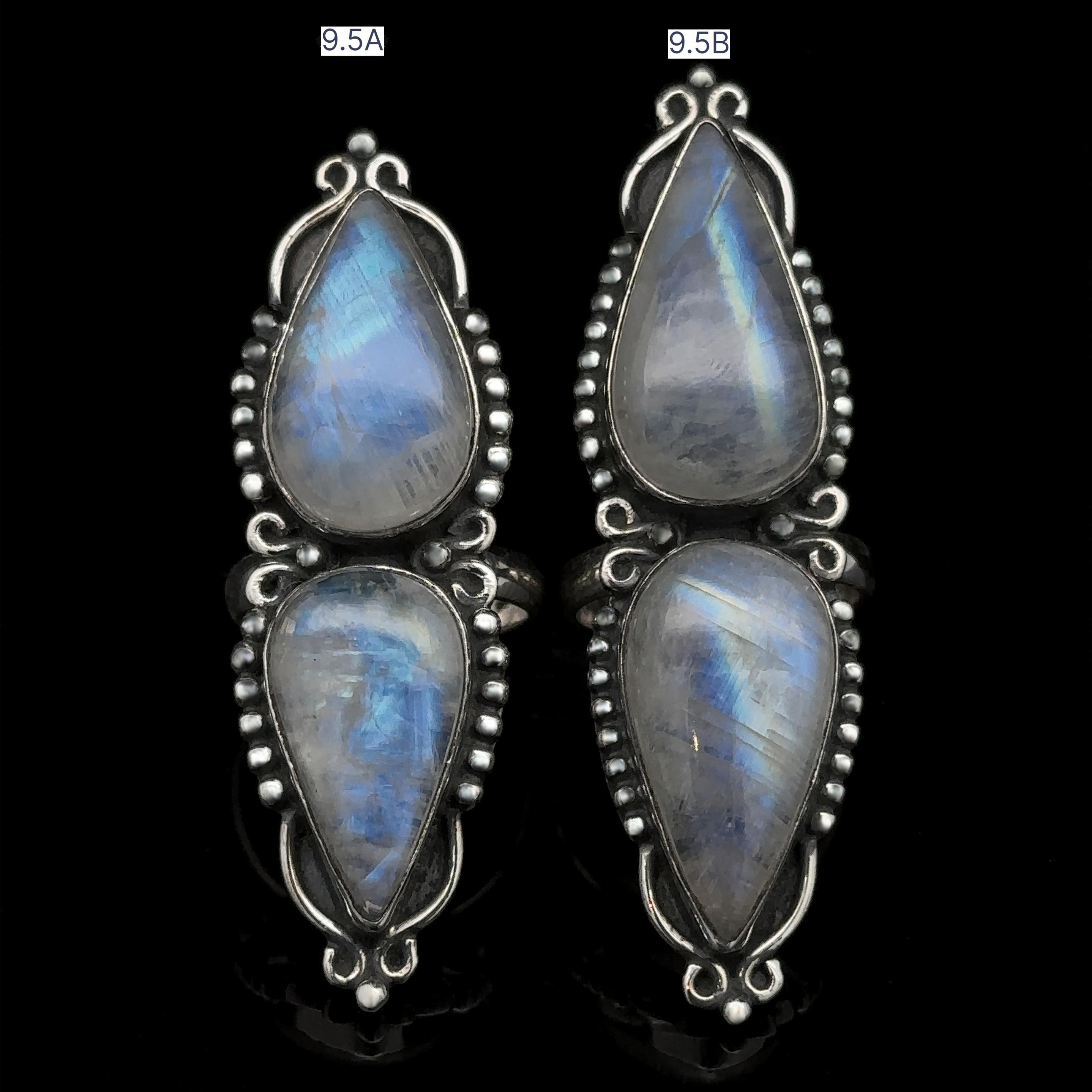 The Long Double Teardrop Moonstone Ring is a pair of sterling silver rings featuring teardrop-shaped moonstone gemstones, each adorned with intricate silver details around the stones for a stunning statement piece.