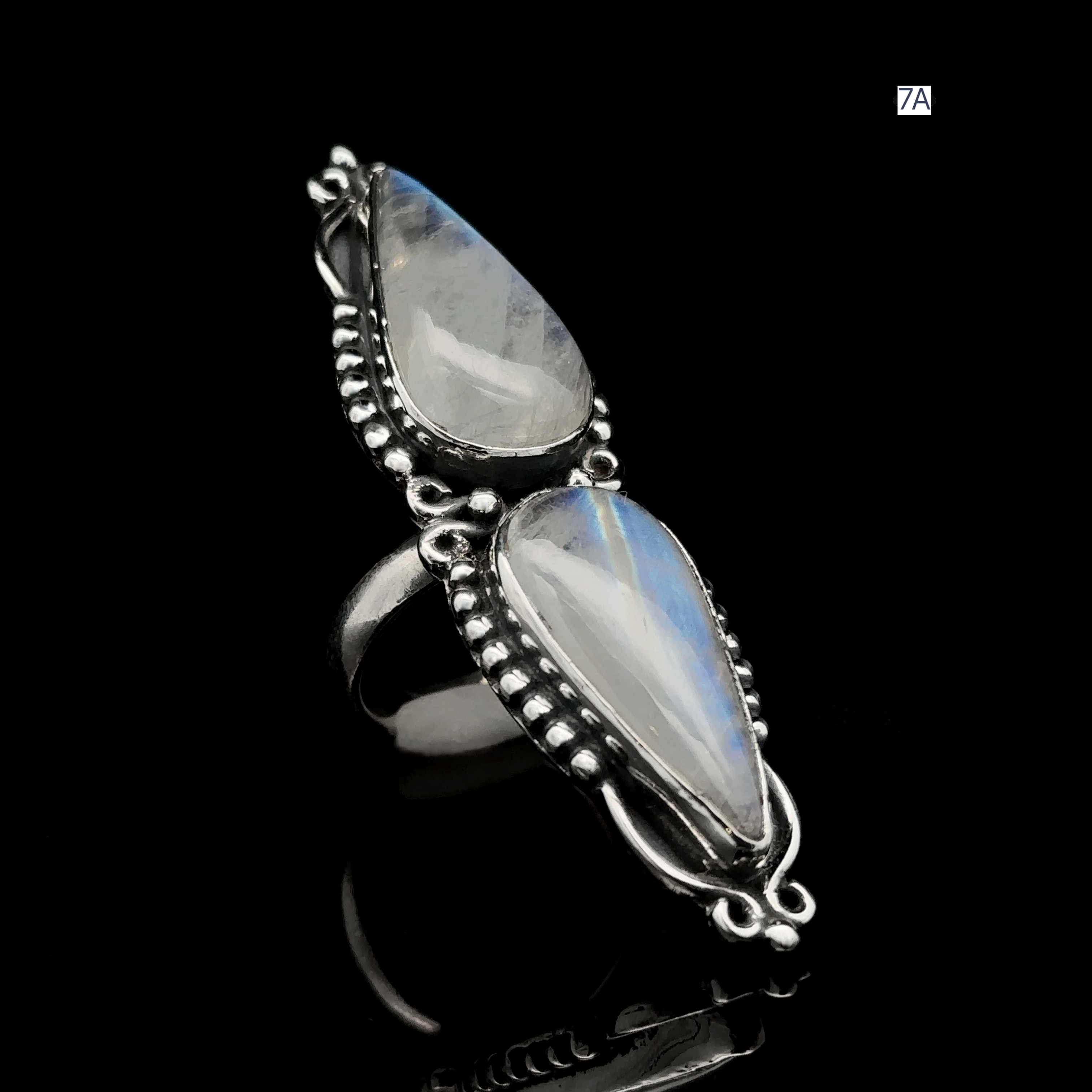Long Double Teardrop Moonstone Ring, set in ornate sterling silver and displayed on a black background.