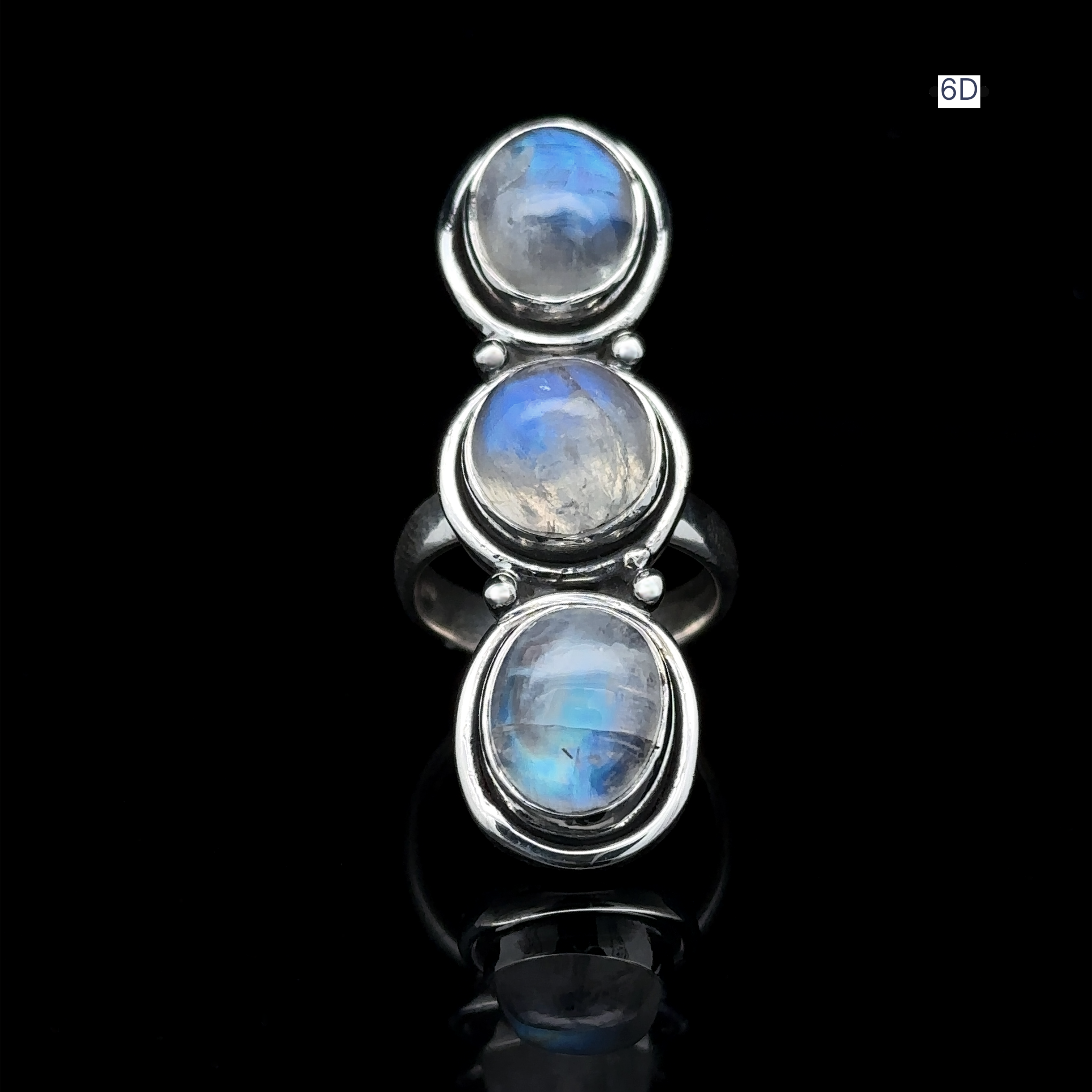 Introducing the Triple Moonstone Ring: a sterling silver creation featuring three round moonstones set vertically against a striking black background, exuding an enchanting goddess energy.