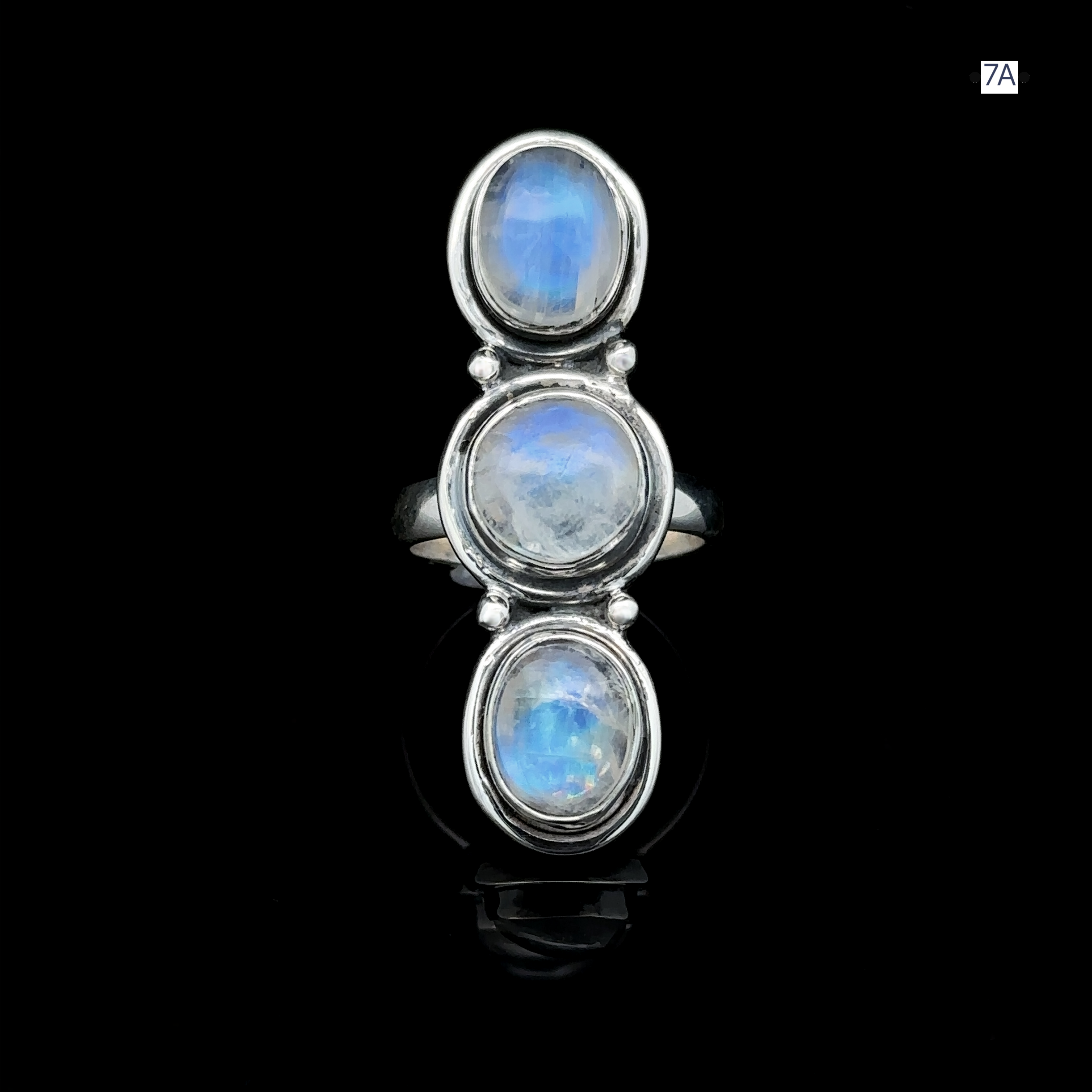 The Triple Moonstone Ring features three oval moonstone cabochons set vertically against a black background, radiating goddess energy.