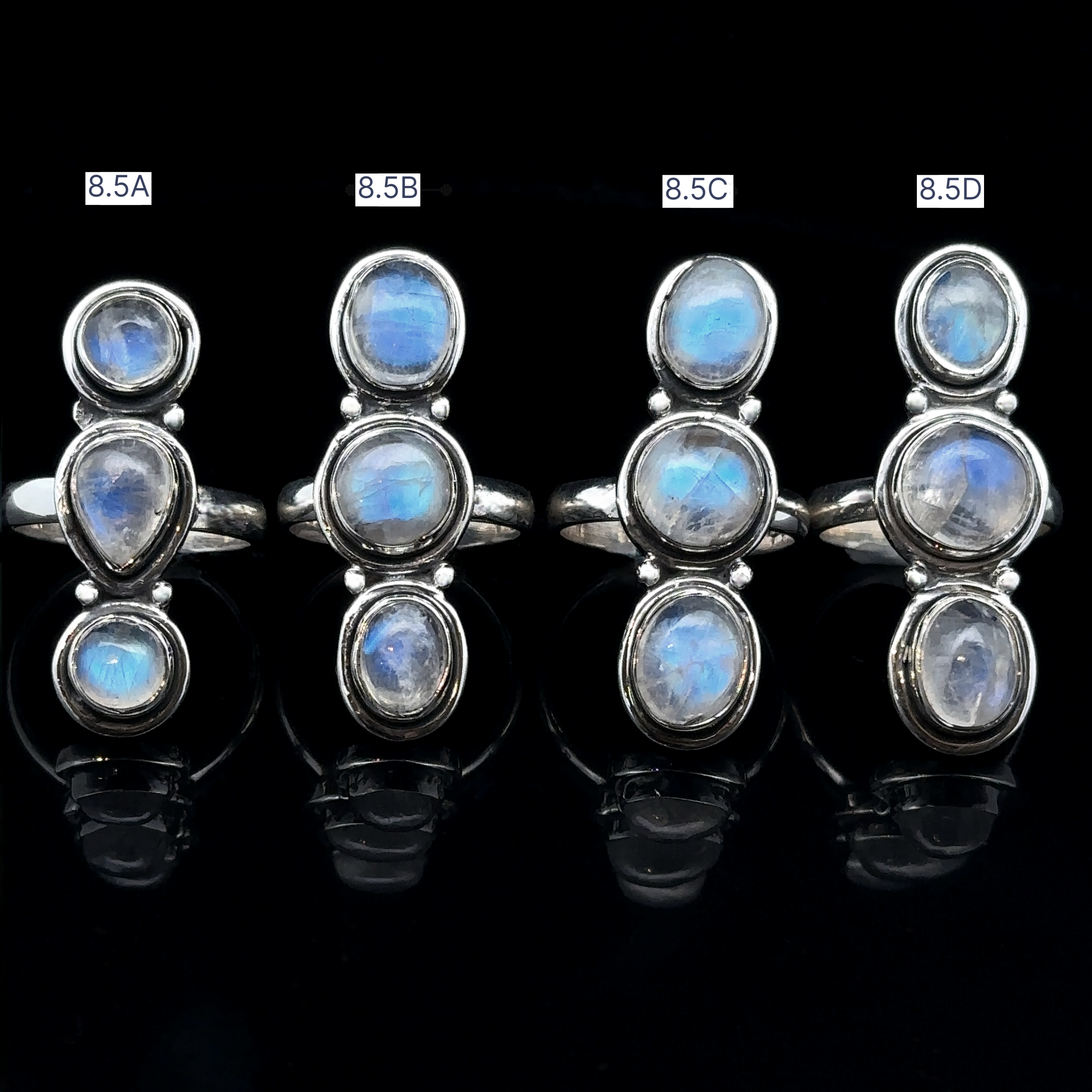 Four Triple Moonstone Rings, labeled 8.5A to 8.5D, displayed in a row on a black background, exuding goddess energy.