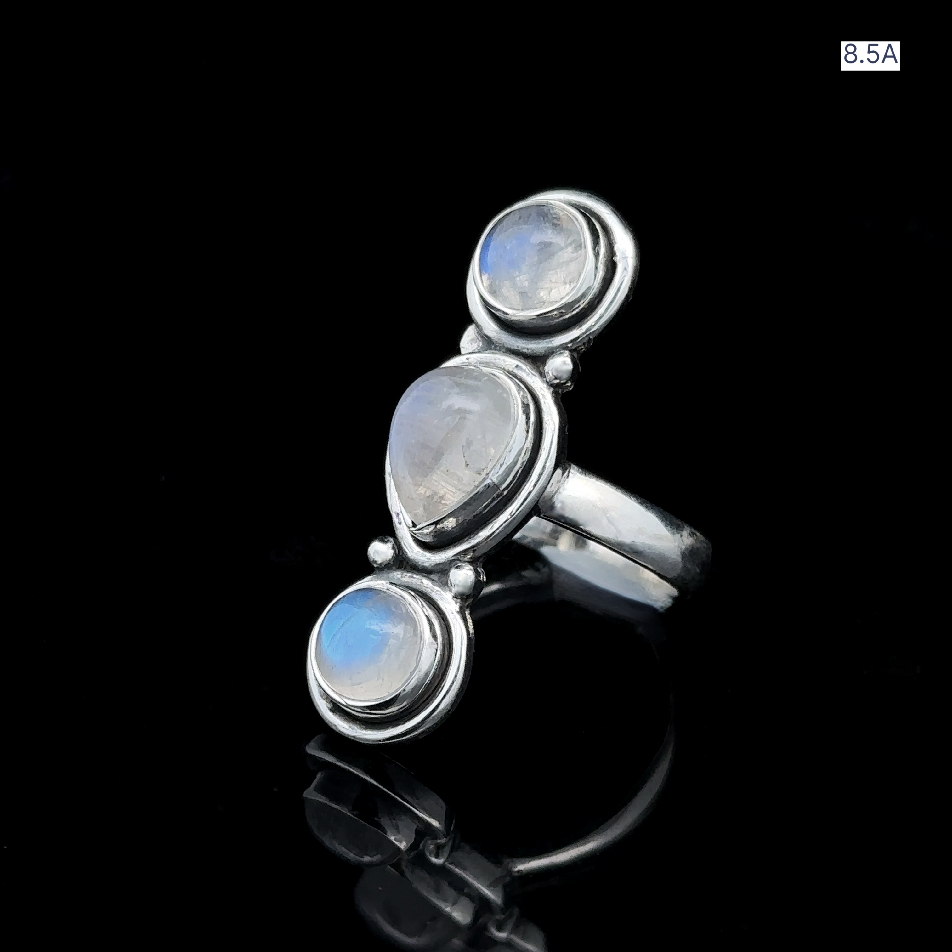 Triple Moonstone Ring crafted from sterling silver features a teardrop-shaped moonstone centerpiece flanked by two round moonstones. The design channels goddess energy and is presented against a black background, marked with the label "8.5A" in the corner.