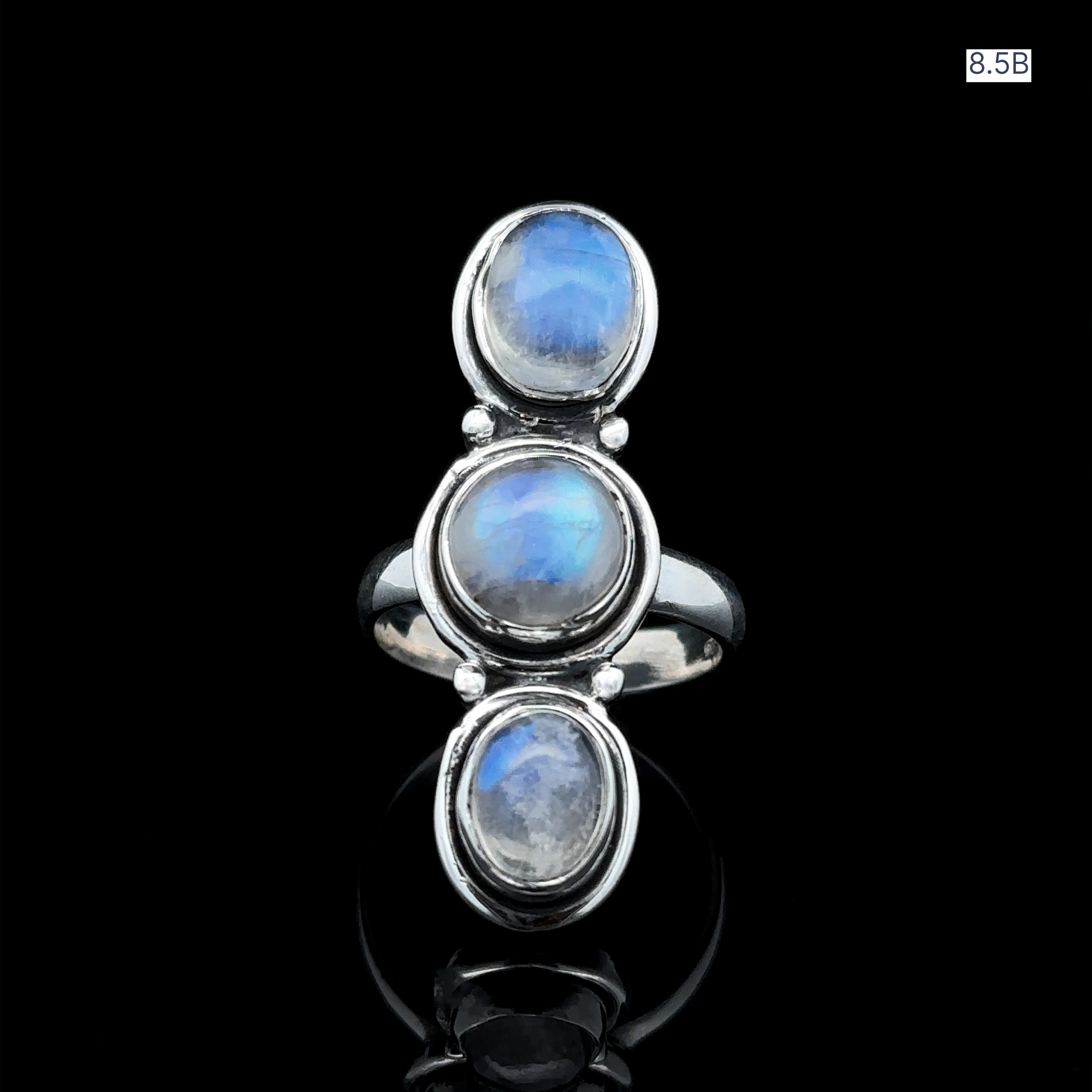 The Triple Moonstone Ring is crafted from sterling silver and features three vertically aligned oval moonstones set against a black backdrop, radiating goddess energy.