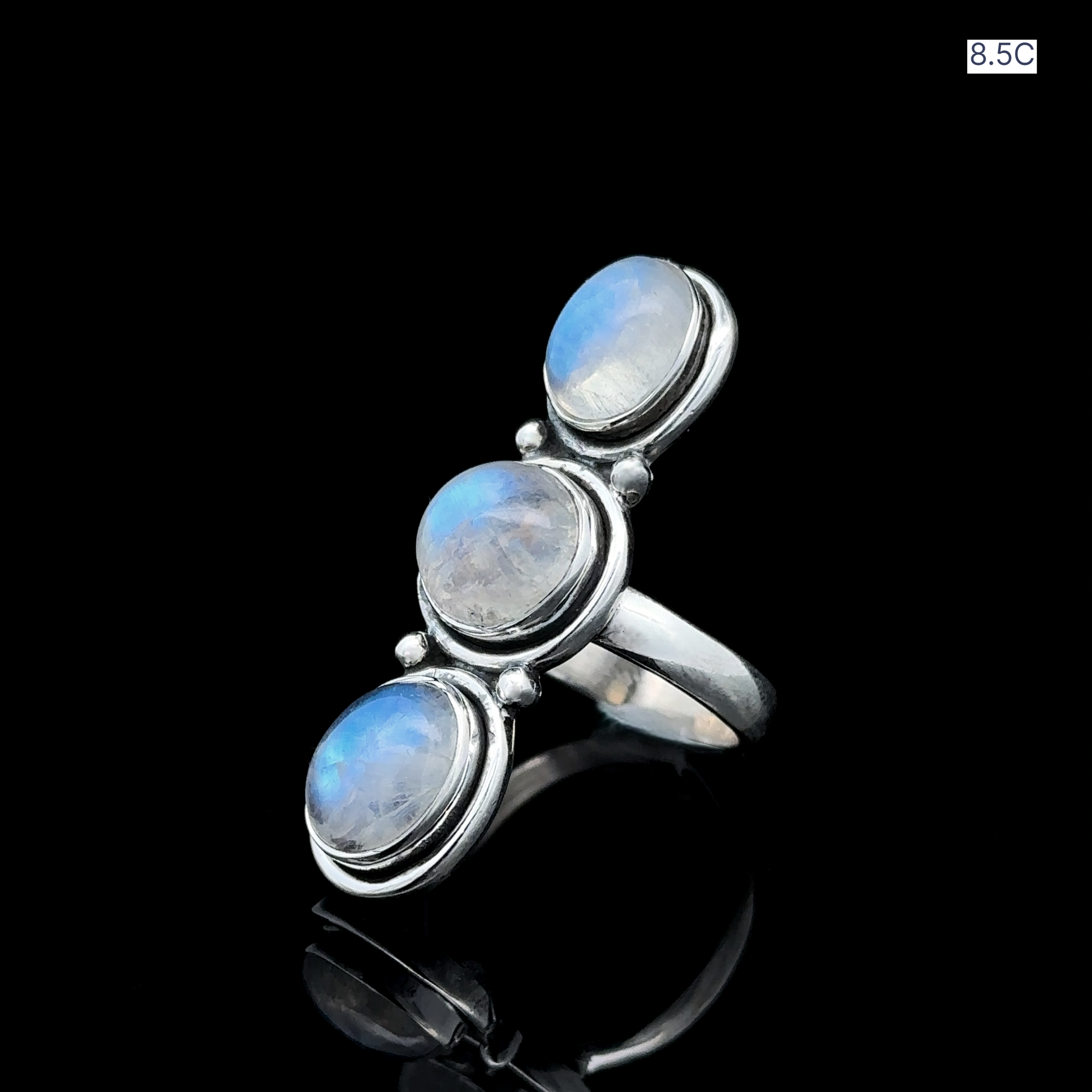 Triple Moonstone Ring showcasing three radiant moonstone gems arranged vertically in sterling silver, exuding goddess energy against a black background.