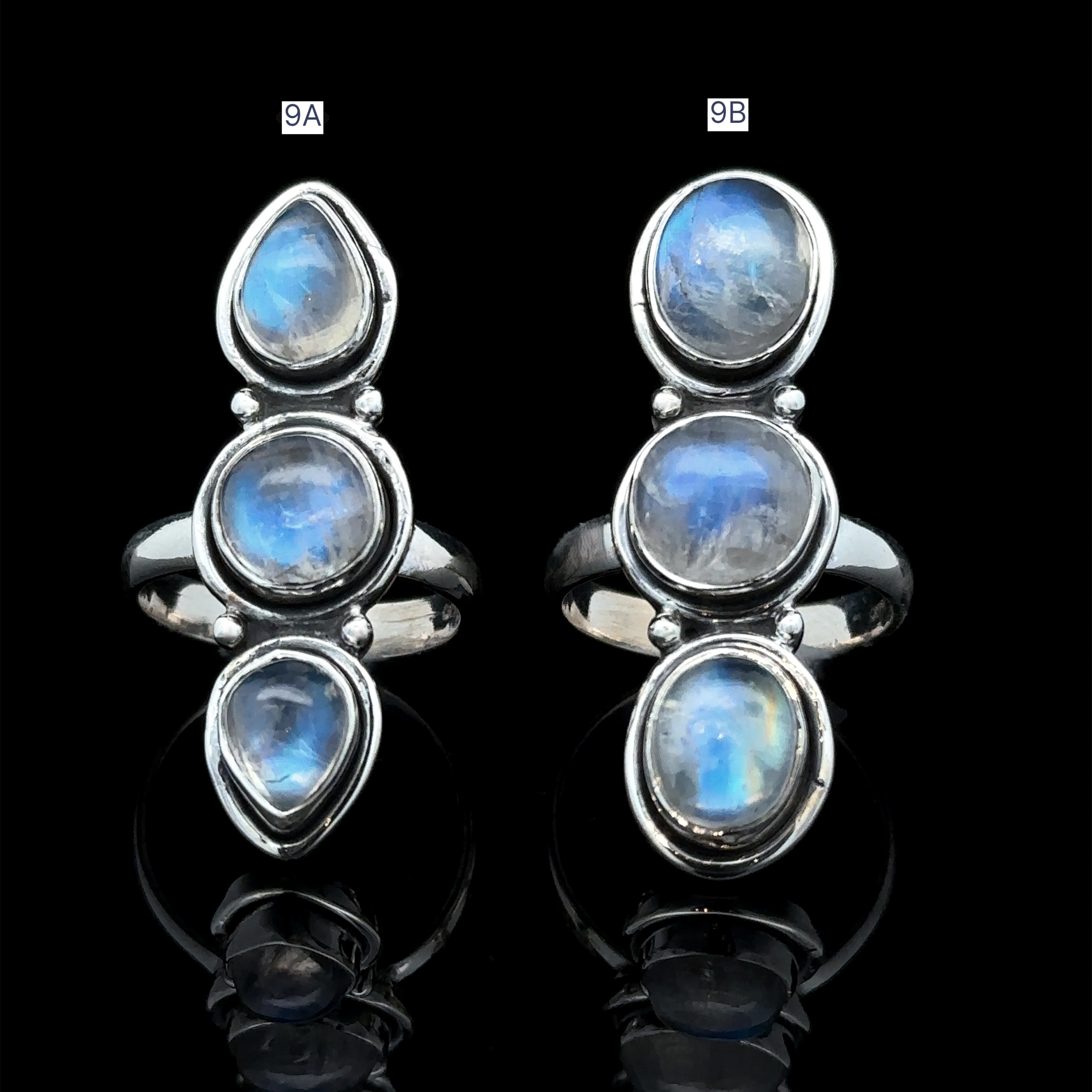 The Triple Moonstone Ring, crafted in sterling silver and featuring a vertical arrangement of three moonstone gems that evoke goddess energy, is displayed on a reflective black surface.