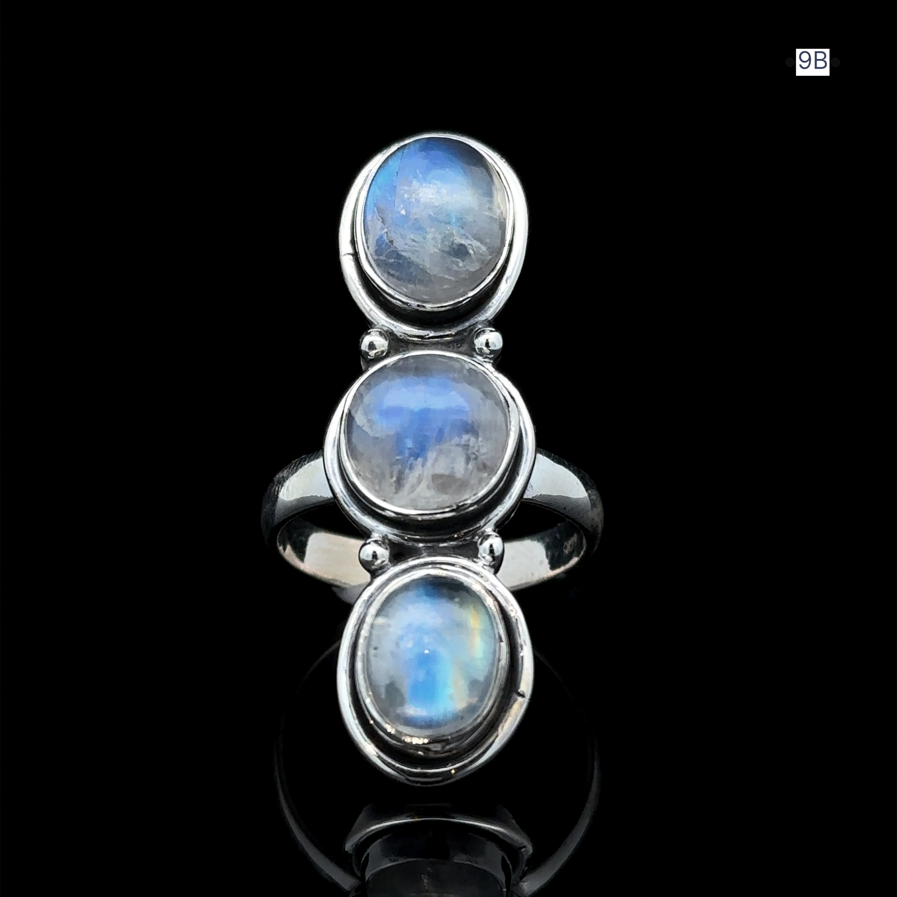 The Triple Moonstone Ring is a sterling silver piece featuring three oval moonstone gemstones arranged vertically on a black background, exuding powerful goddess energy.