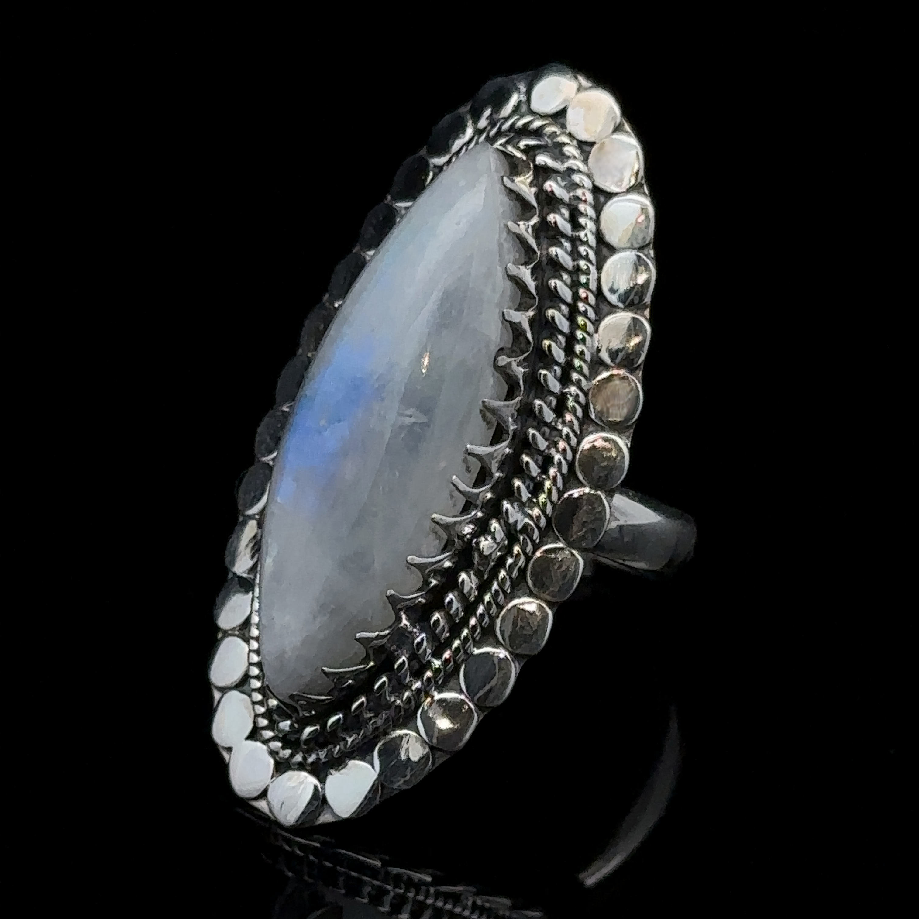 Statement Marquise Shaped Gemstone Ring with an elongated oval translucent stone, set in an ornate, textured bezel with a dot-patterned border, displaying the essence of Bohemian jewelry against a black background.