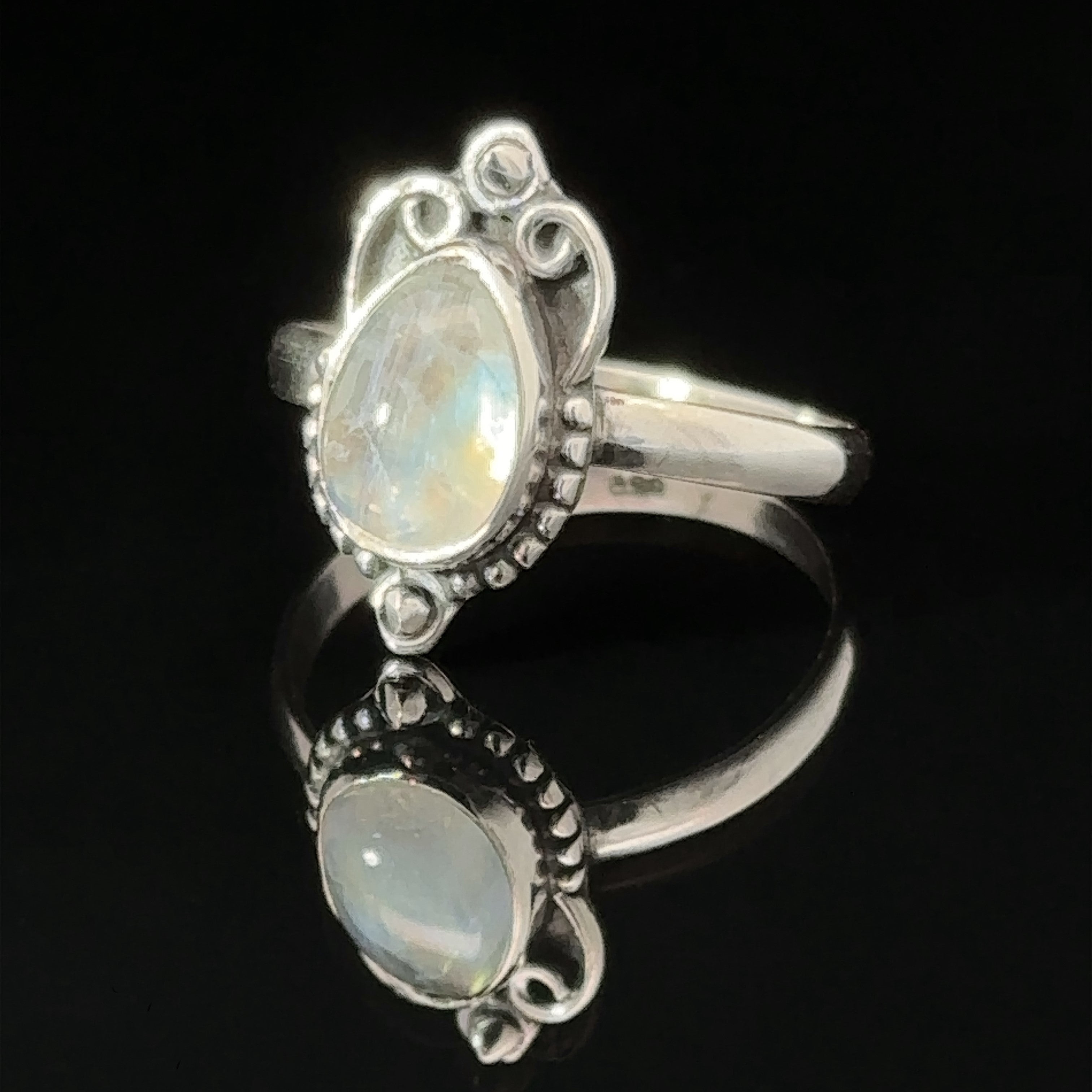 Vintage Inspired Teardrop Gemstone Ring with a opal set in an ornate band, displayed against a black background.