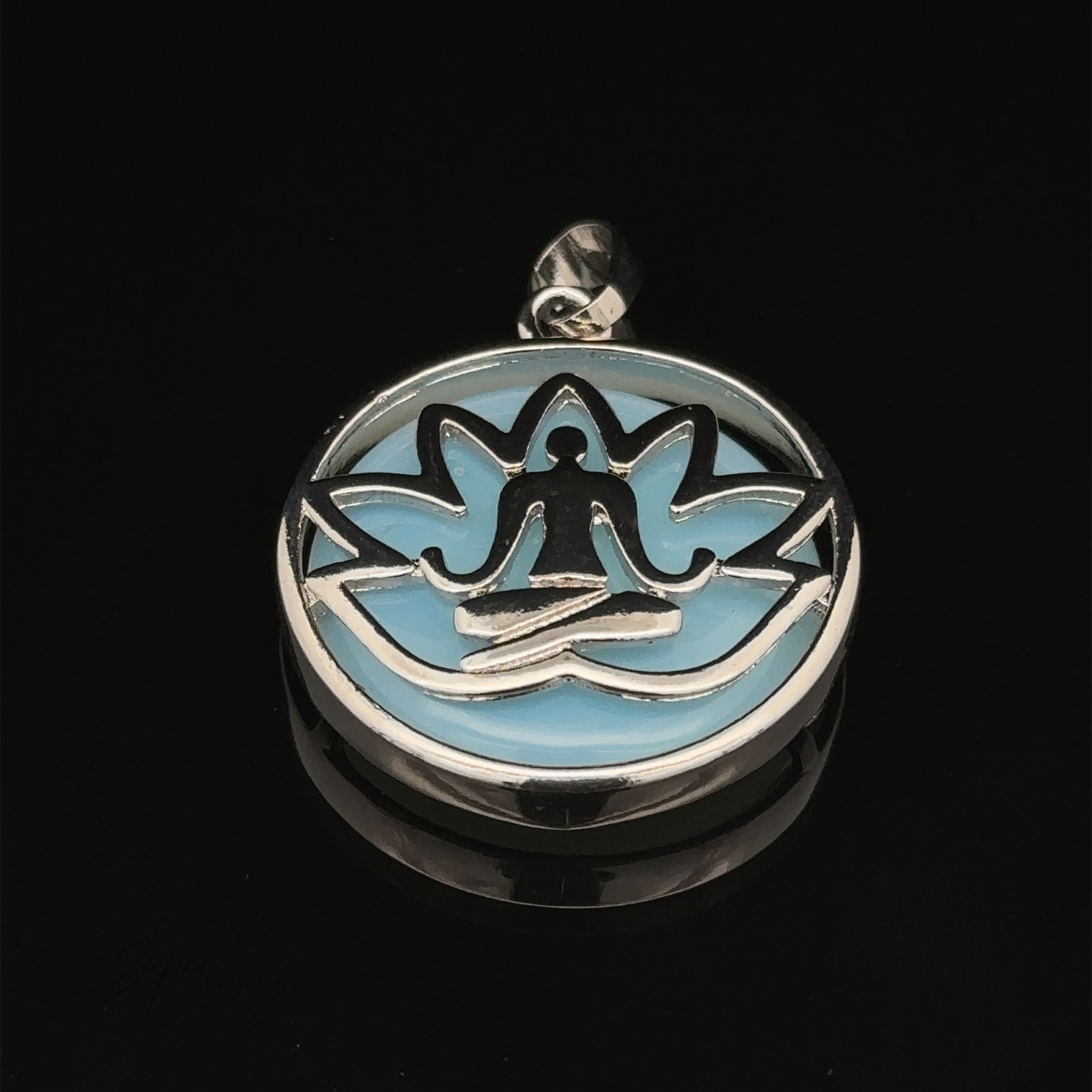 A Silver Plated Lotus Meditation Pendant with Gemstone featuring a person in a meditative pose, set against a blue background with intricate lotus flower petals.
