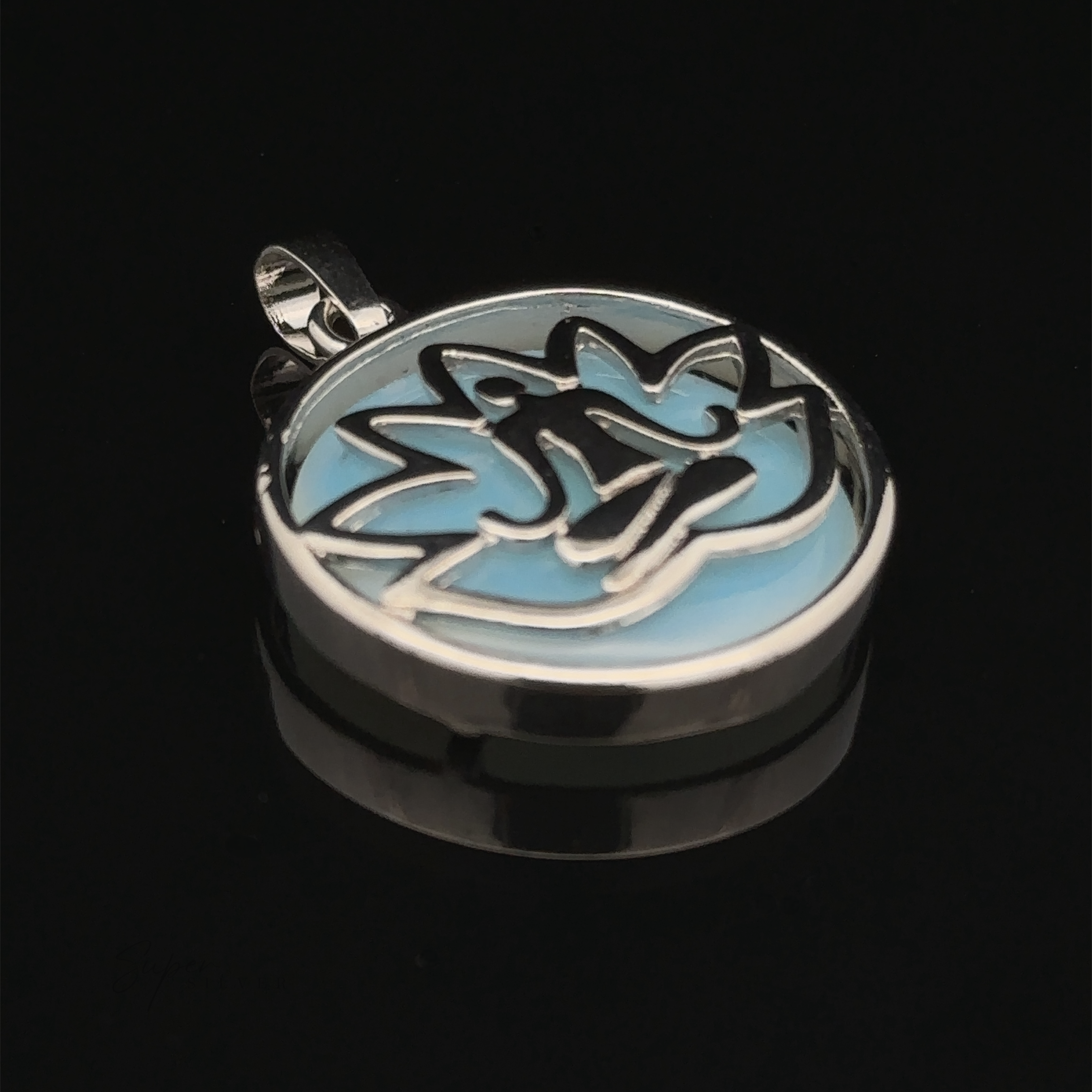 A Silver Plated Lotus Meditation Pendant with Gemstone featuring a stylized lotus design with blue enamel details and a striking black background.