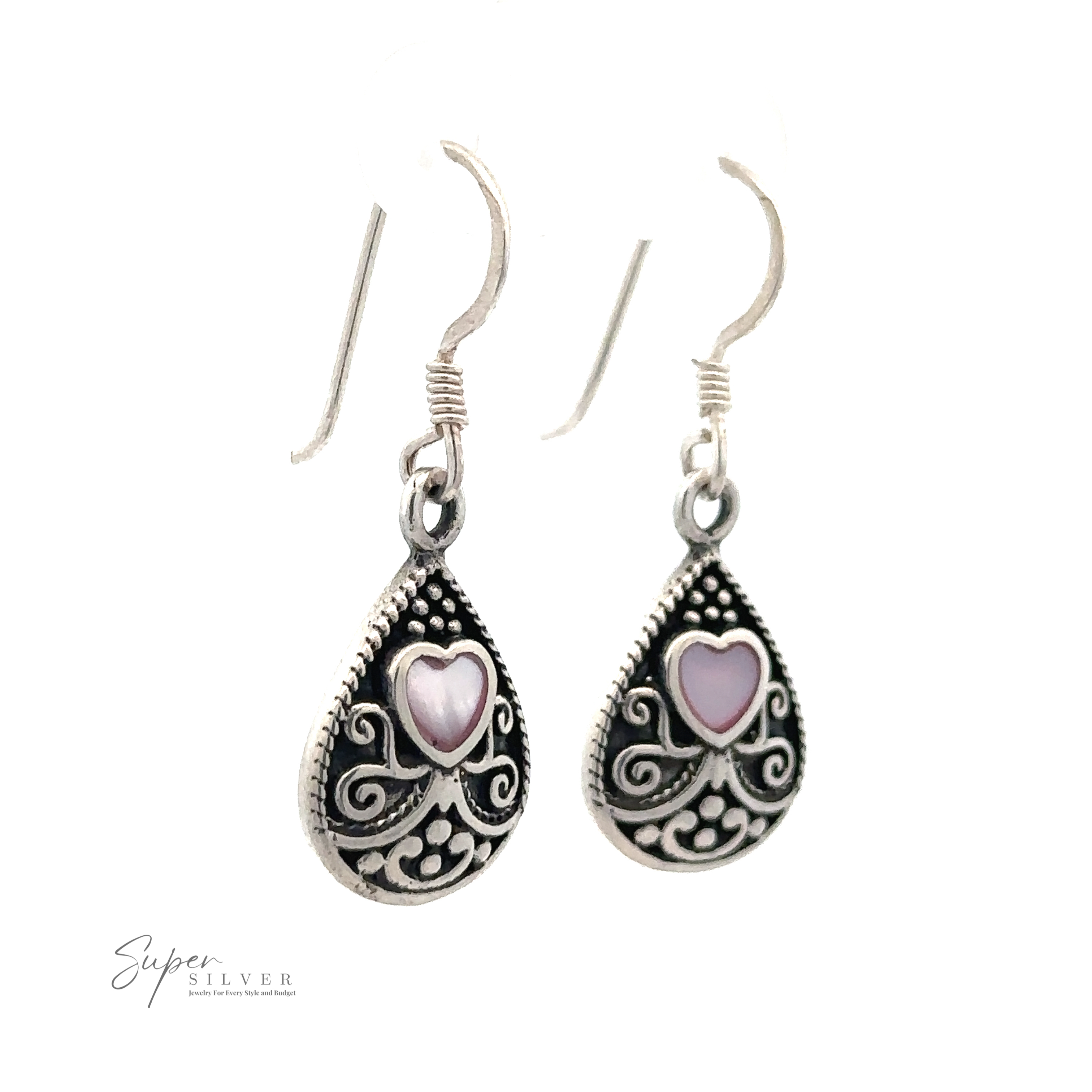 A pair of Bali Style Teardrop Earrings with Inlaid Stone, with intricate filigree designs and pink mother-of-pearl heart-shaped accents, crafted from sterling silver and hanging on simple ear hooks.