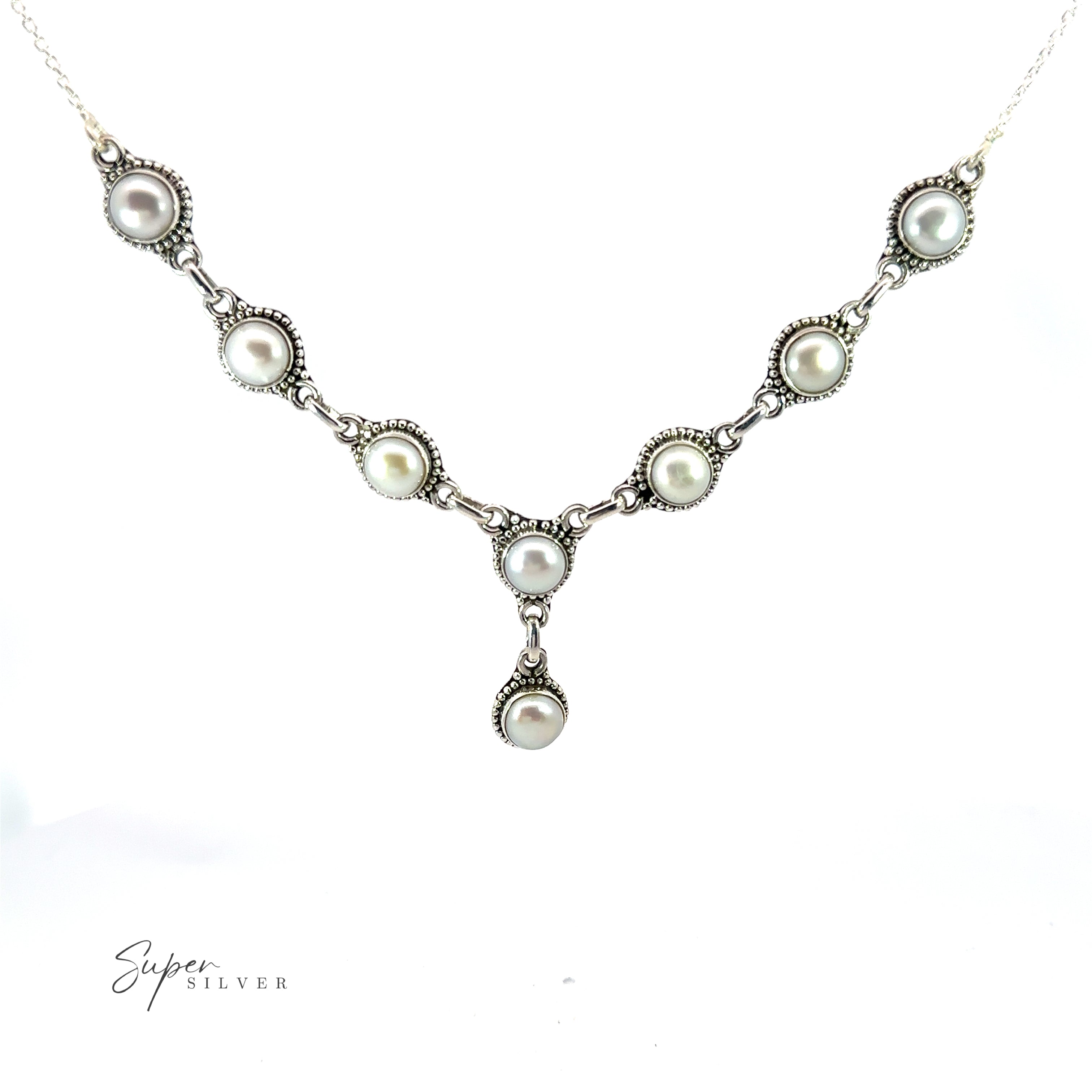 A Round Gemstone Y Necklace with Ball Border featuring a symmetrical arrangement of round pearls set in decorative settings, with a single pearl pendant hanging in the center. This exquisite piece adds a touch of bohemian style to any outfit, seamlessly blending elegance with laid-back charm.