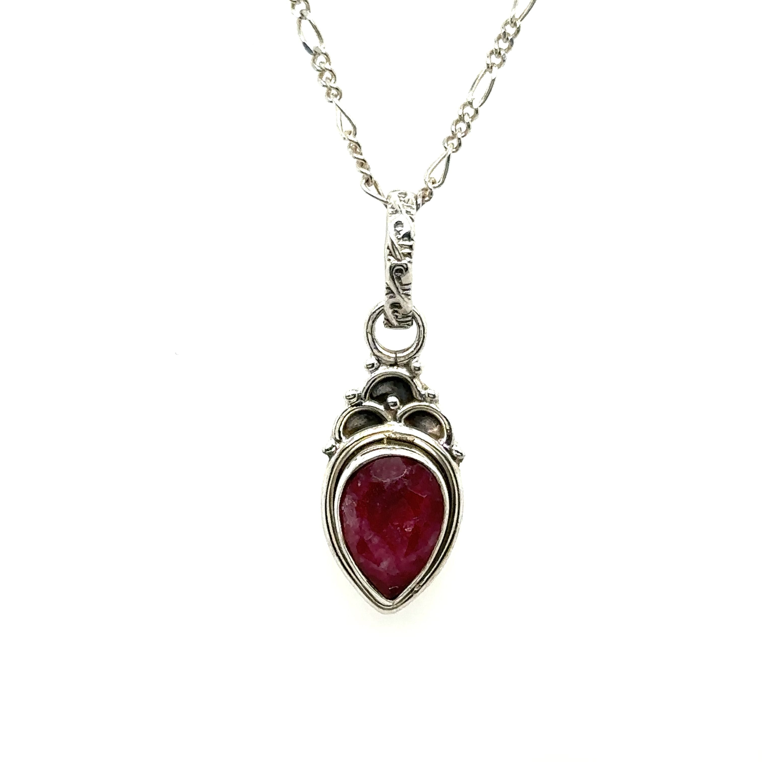 A Dainty Gemstone Teardrop Pendant with a ruby stone on a silver chain.