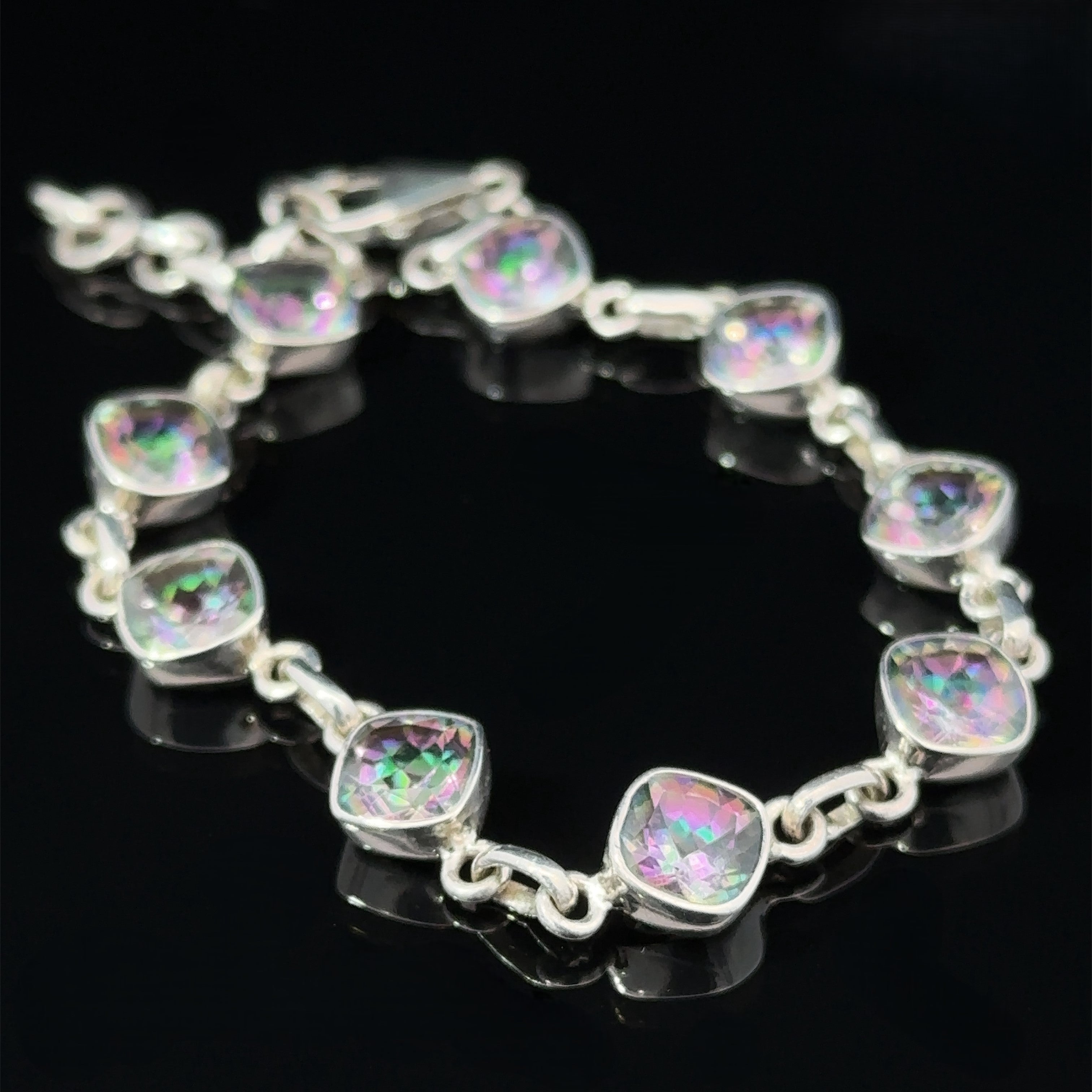 A Rainbow Mystic Topaz Diamond Link Bracelet with iridescent, multifaceted Mystic Topaz stones arranged in a diamond link pattern against a black background.