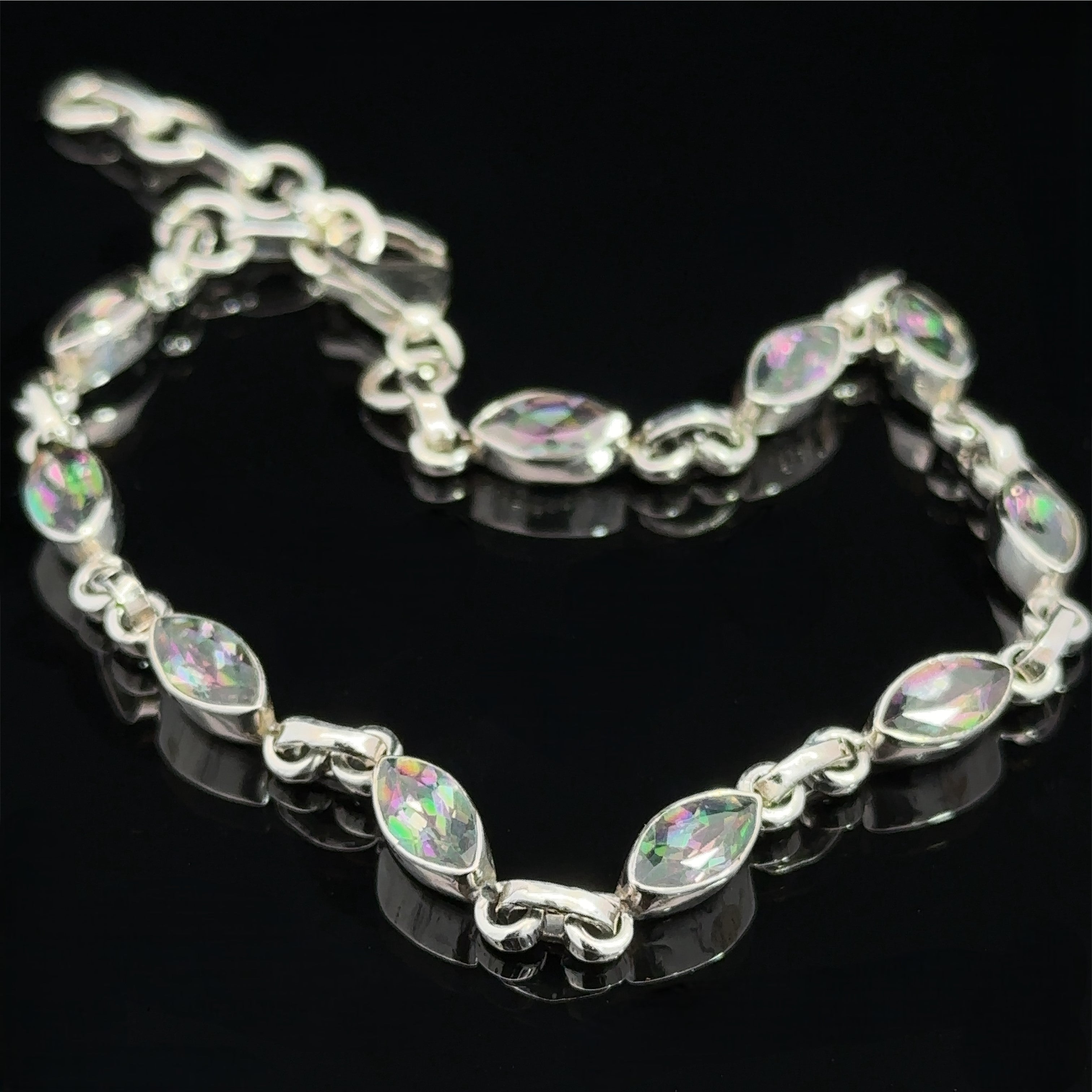 Displayed on a black background, a Rainbow Mystic Topaz Marquise Link Bracelet linked together exudes elegance.