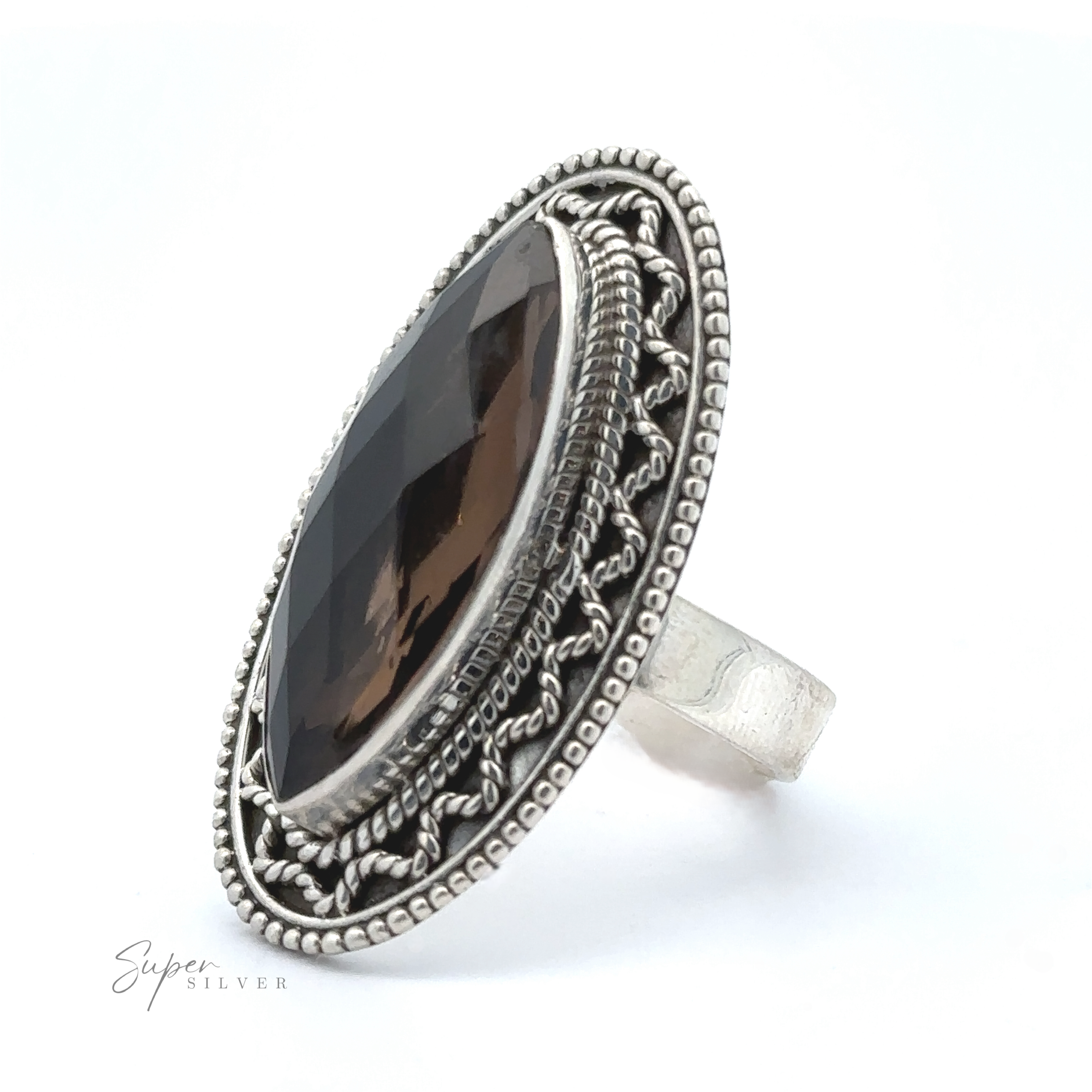 A Marquise Shaped Gemstone Ring With Vintage Shield Border featuring a large marquise-cut dark gemstone, surrounded by intricate detailing on the band, giving it a Bohemian twist.
