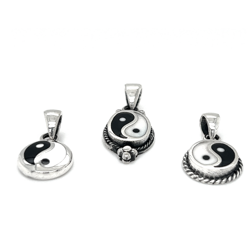 Three Various Yin-Yang Pendants showcasing balance on a white background.