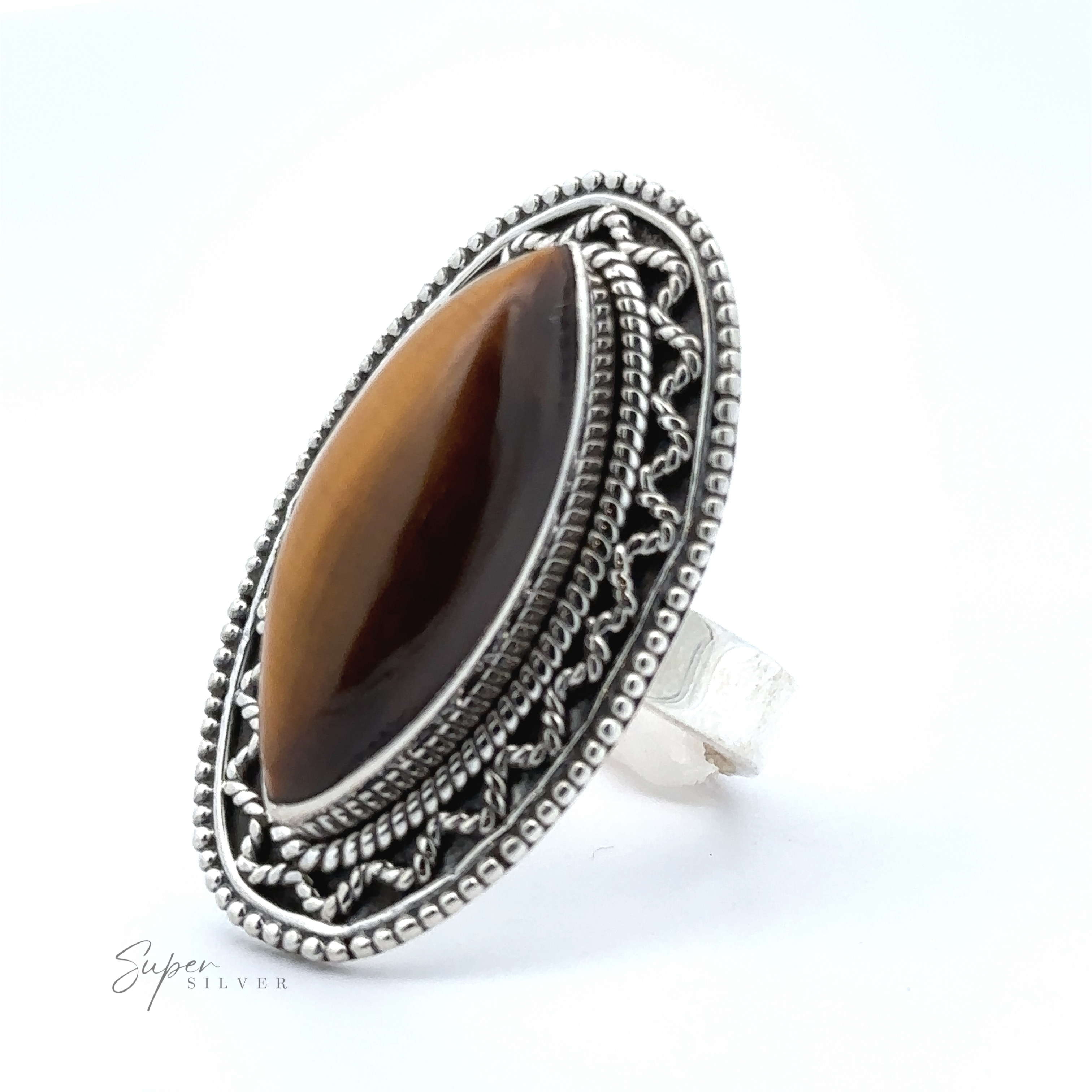 A marquise shaped gemstone ring with vintage shield border, featuring an oval-shaped brown gemstone in the center. The ring, marked "Super Silver," exudes a subtle bohemian twist.