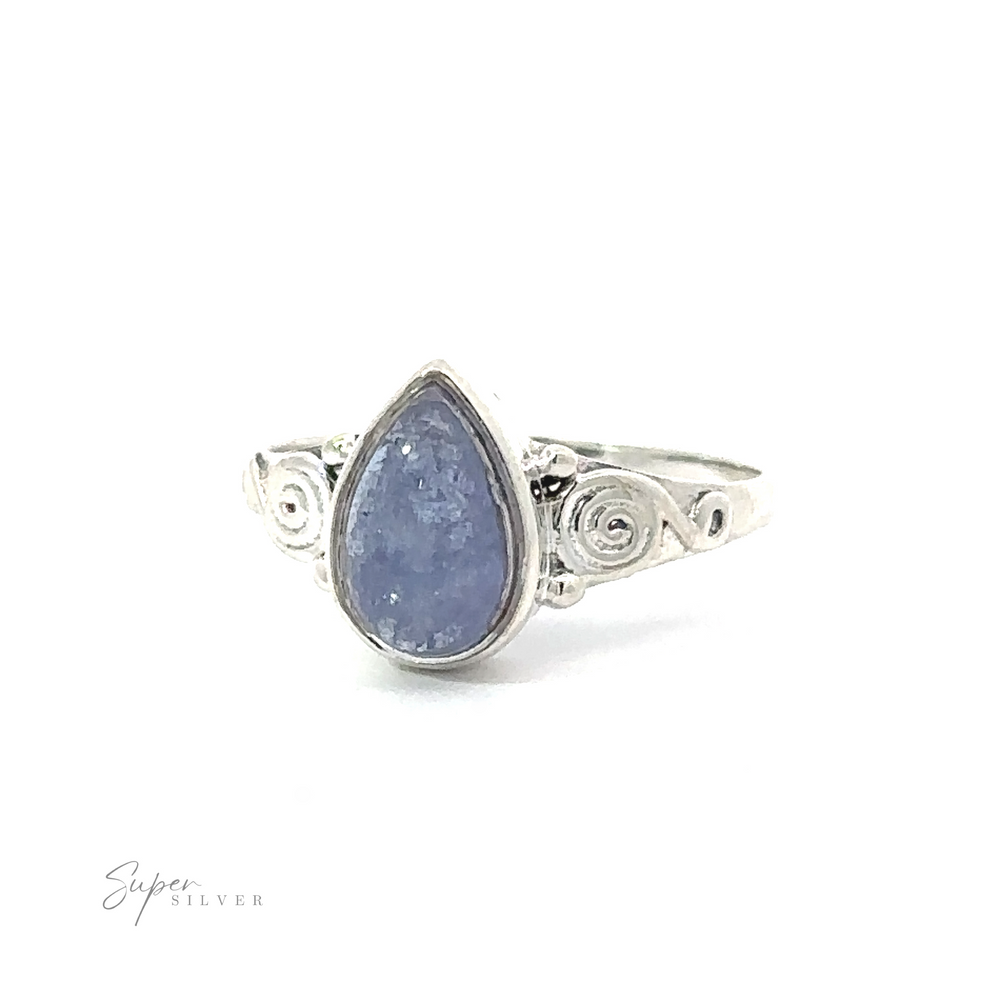 
                  
                    Teardrop Gemstone Ring With Swirls featuring a teardrop, pale blue gemstone set in an intricate band with spiral designs and a touch of bohemian flair, against a white background.
                  
                