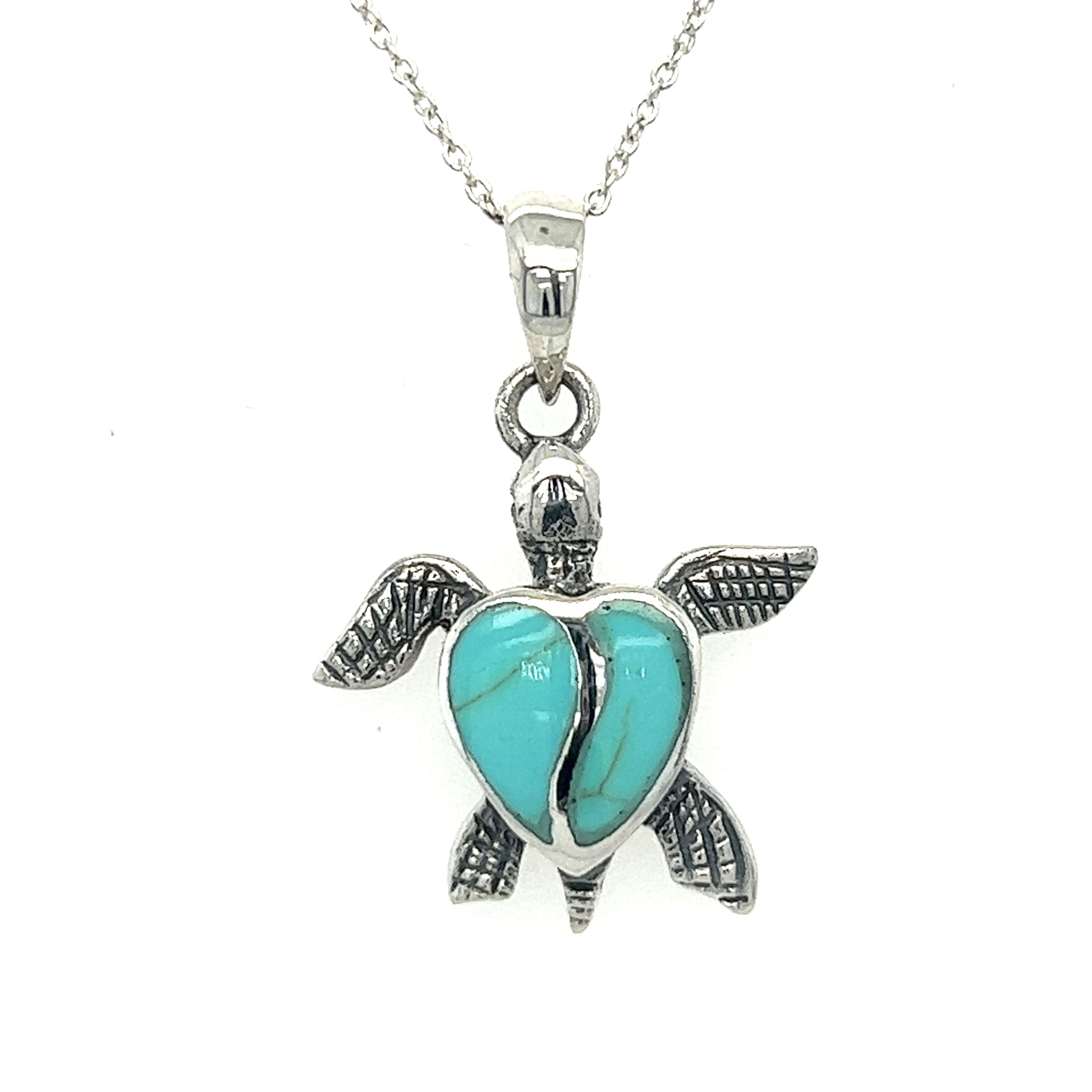 A Stone Inlay Turtle Pendant with turquoise stone on a silver chain.
