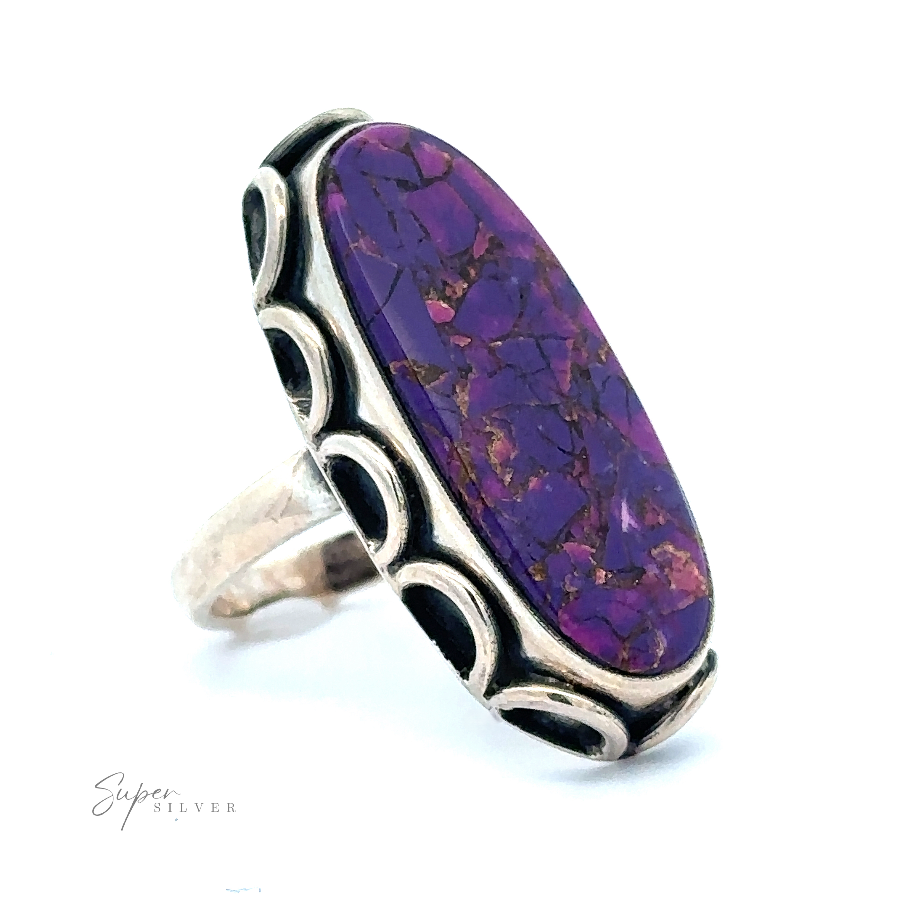 A silver ring featuring an elongated Statement Purple Turquoise Ring stone with intricate metal detailing on the band. The word "Super Silver" is visible on the bottom left corner.