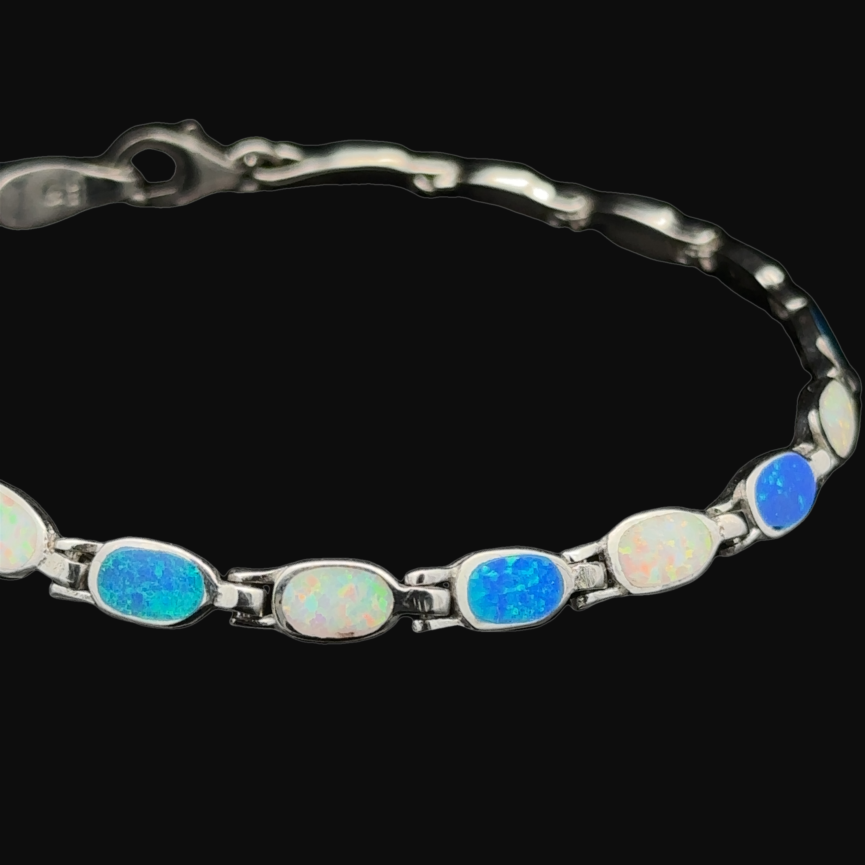The Oval Lab-Created Opal Bracelet, crafted with .925 Sterling Silver, exudes modern elegance with its oval lab-created opal stones elegantly set along the band.