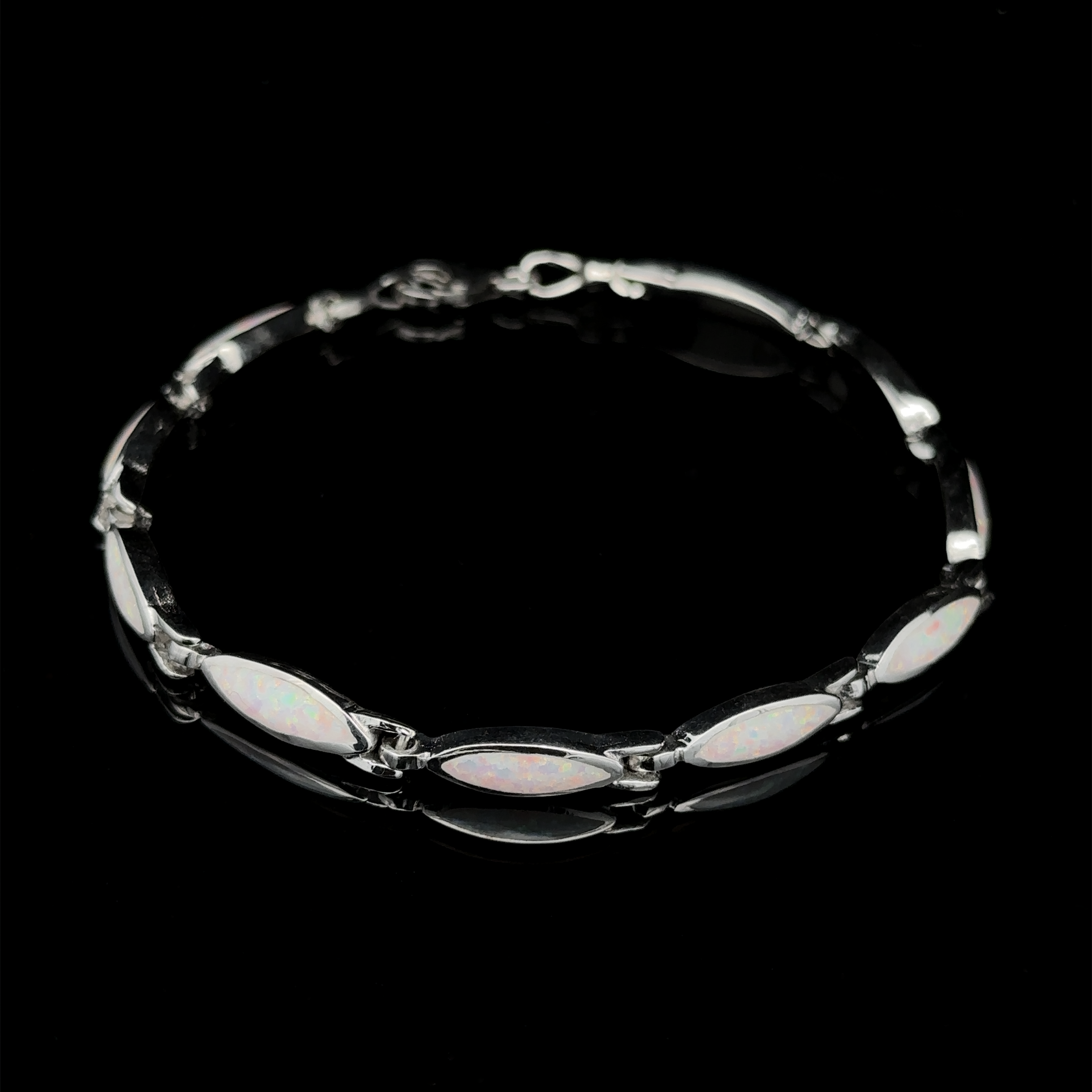 A sleek and stylish lab-created opal bracelet featuring five marquise-shaped stones, set in a sequence of .925 Sterling Silver, resting against a black background.