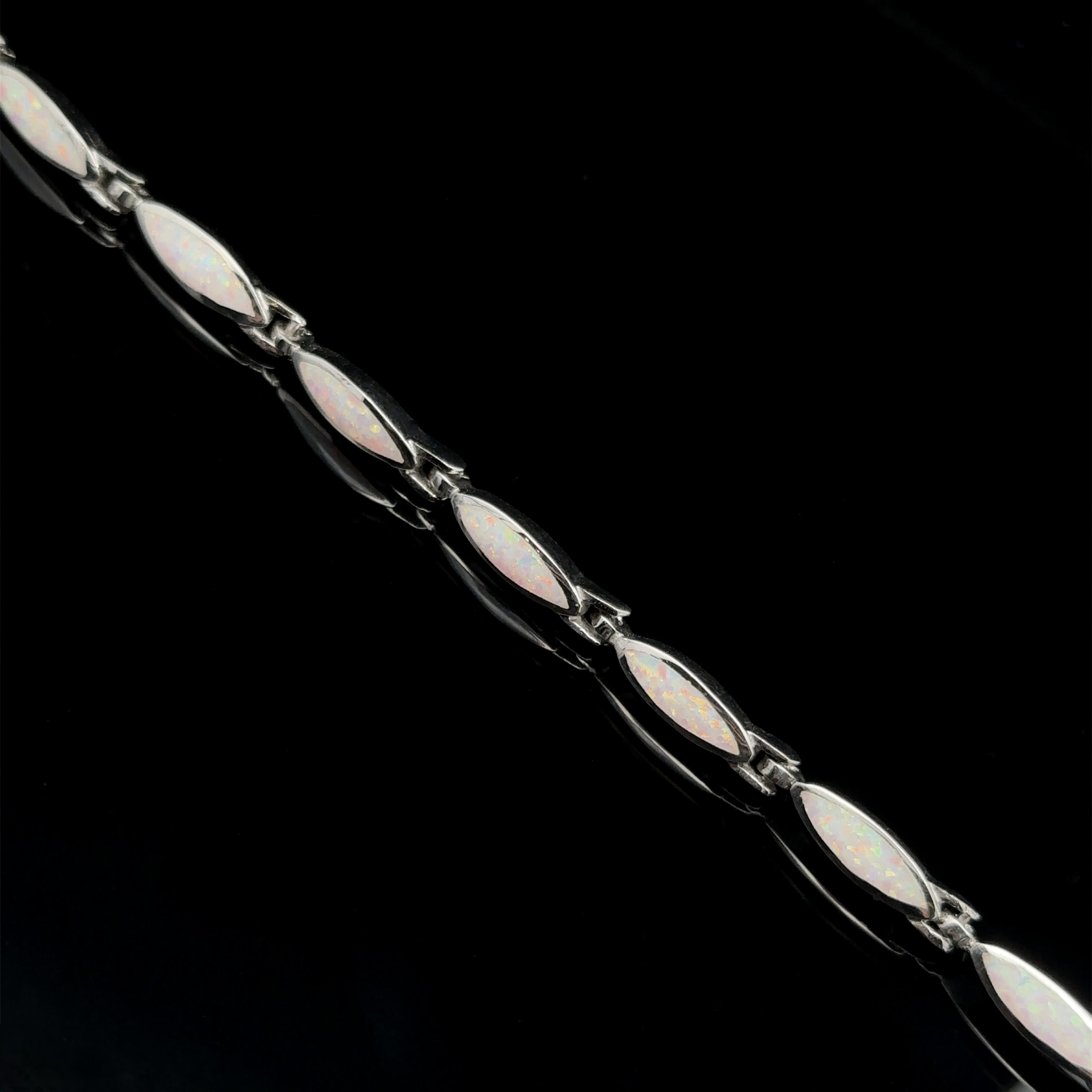 A stunning Marquise Shaped Lab-Created Opal Bracelet in .925 Sterling Silver, featuring marquise-shaped opal stones set in a linked chain, displayed diagonally on a black background.