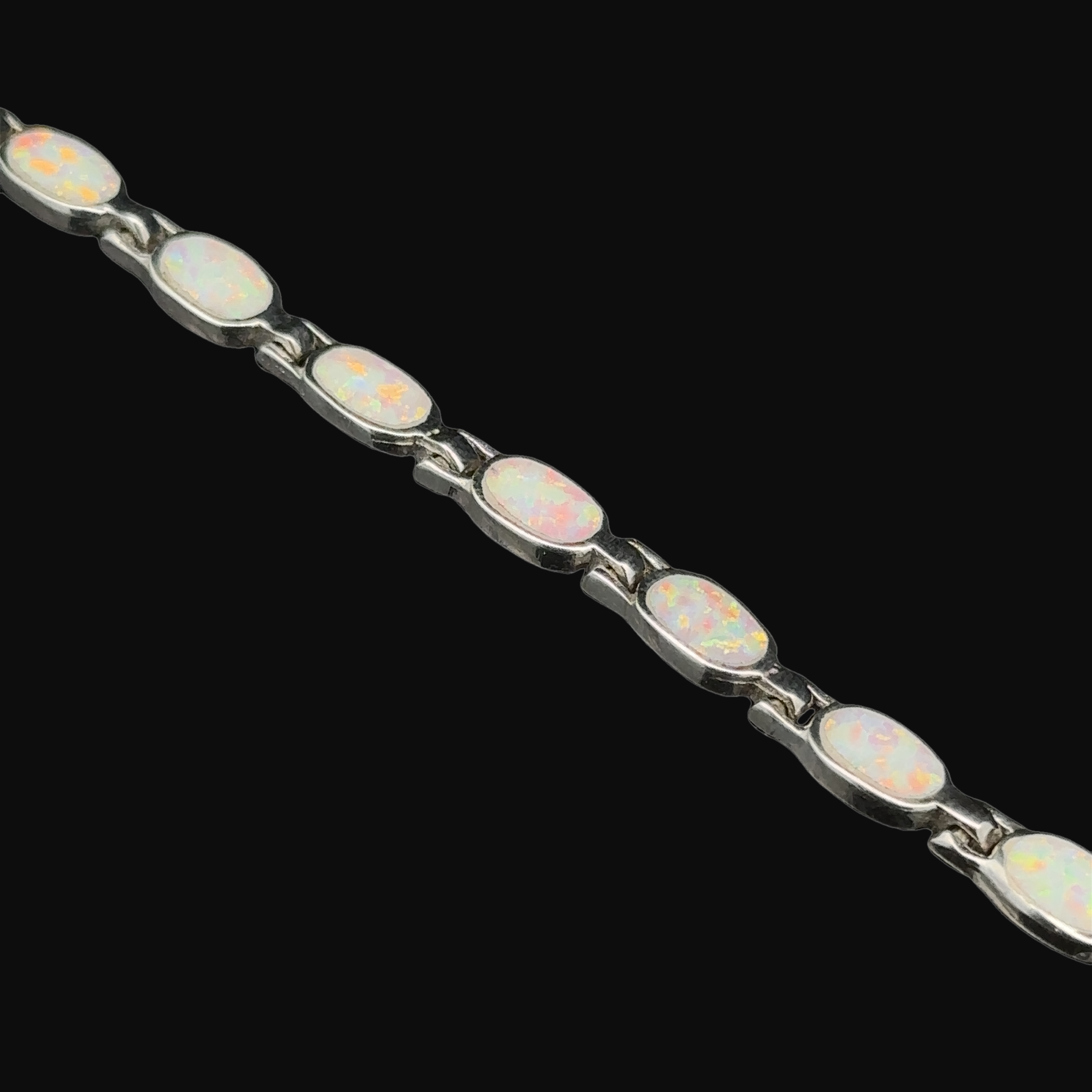 A modern and elegant "Oval Lab-Created Opal Bracelet" featuring white opal stones set in .925 Sterling Silver.