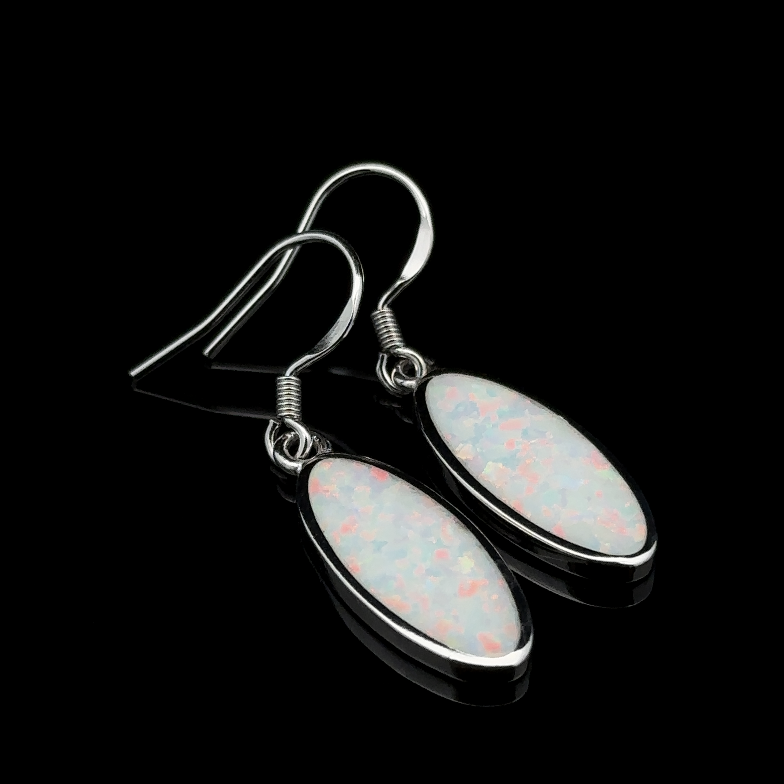 Pair of Simple Oval Lab-Created Opal Earrings featuring sterling silver hooks and elongated oval opals with a white base adorned with pink and blue speckles, set against a black background.