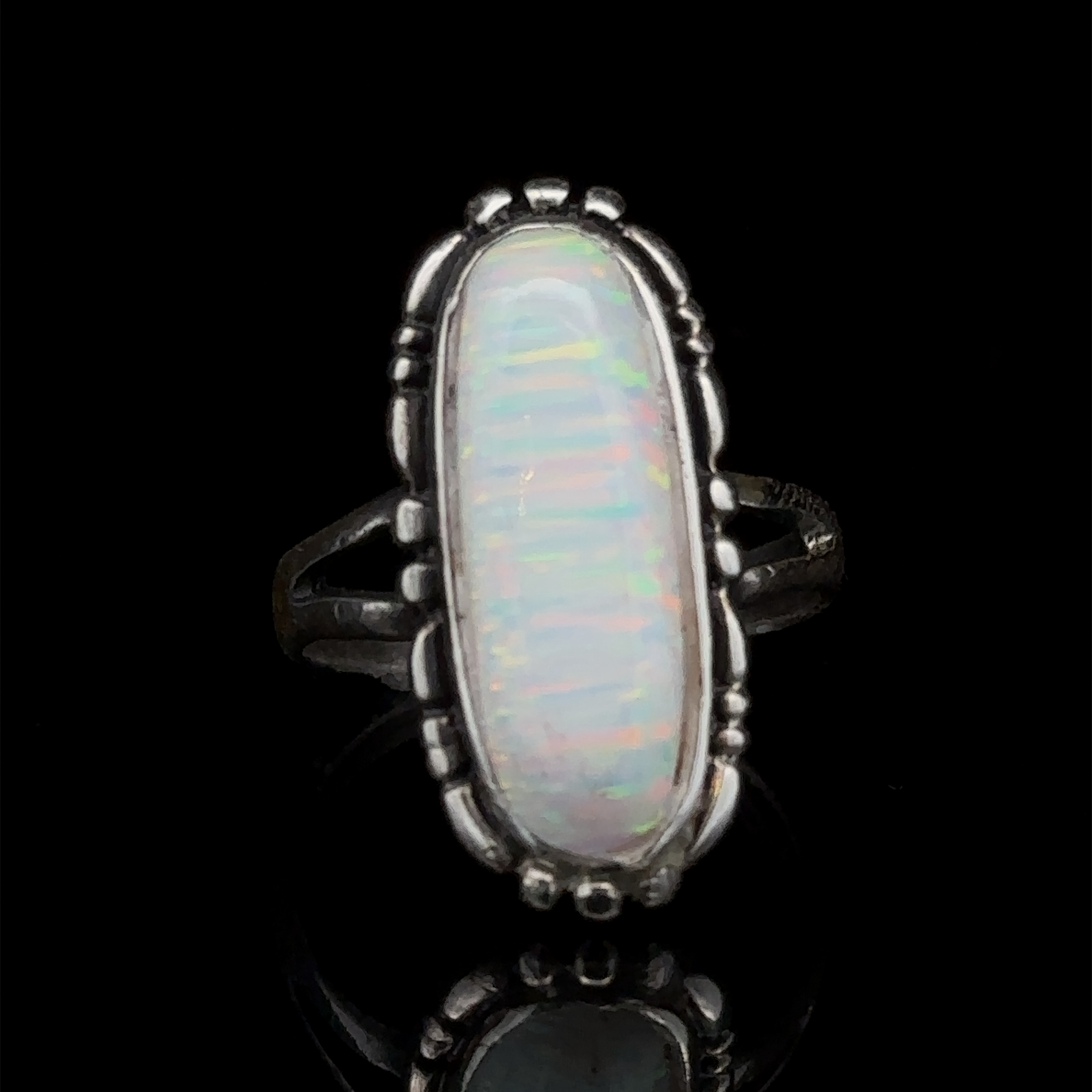 The American Made Oval Opal Ring features a southwestern-styled sterling silver design with an elongated oval lab-created opal showcasing a multi-color iridescent pattern, set against a black background.