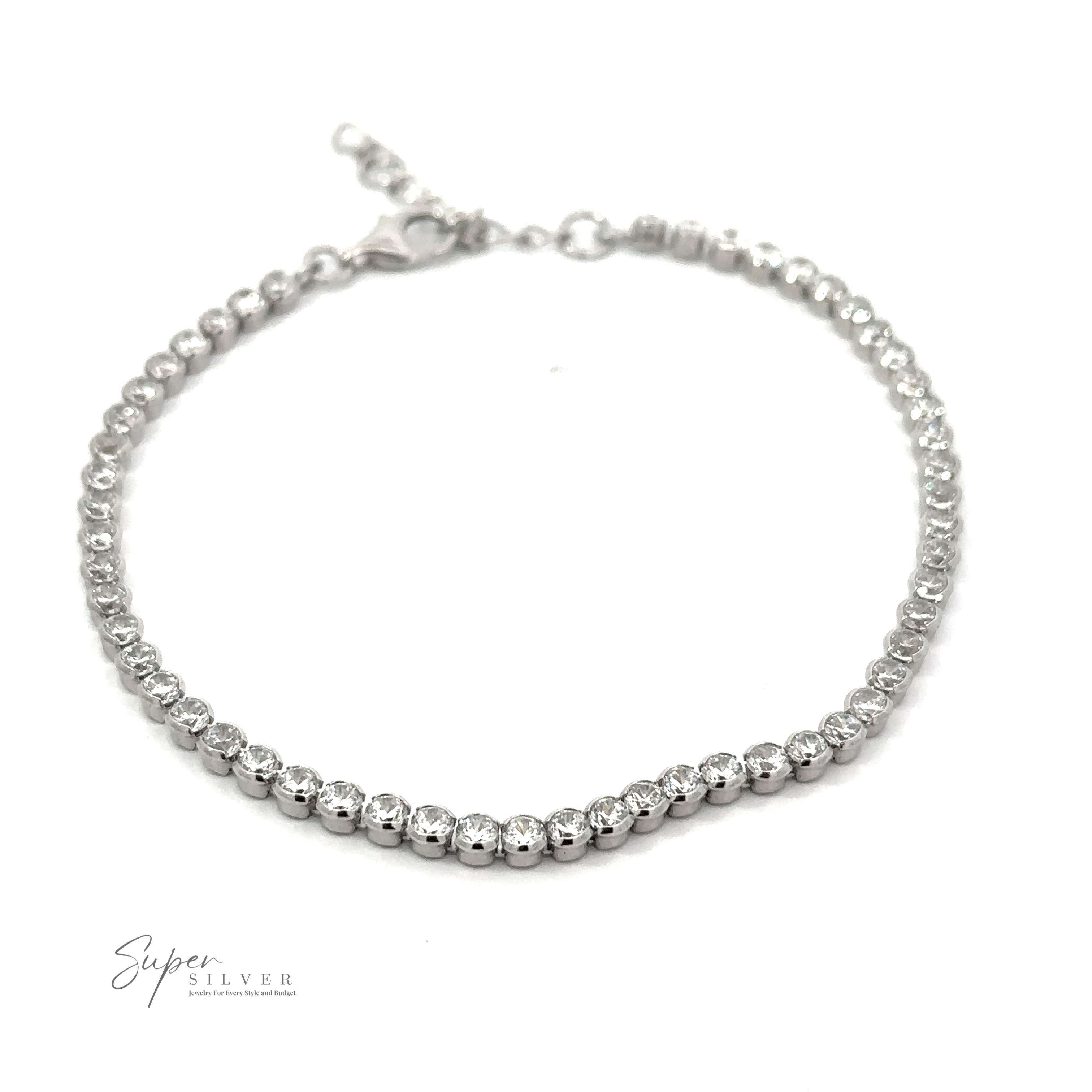 A Round Cubic Zirconia Tennis Bracelet adorned with round cubic zirconia gemstones arranged in a row. The dainty accessory features a clasp at one end and is displayed against a plain background. The logo "Super Silver" is visible in the corner.