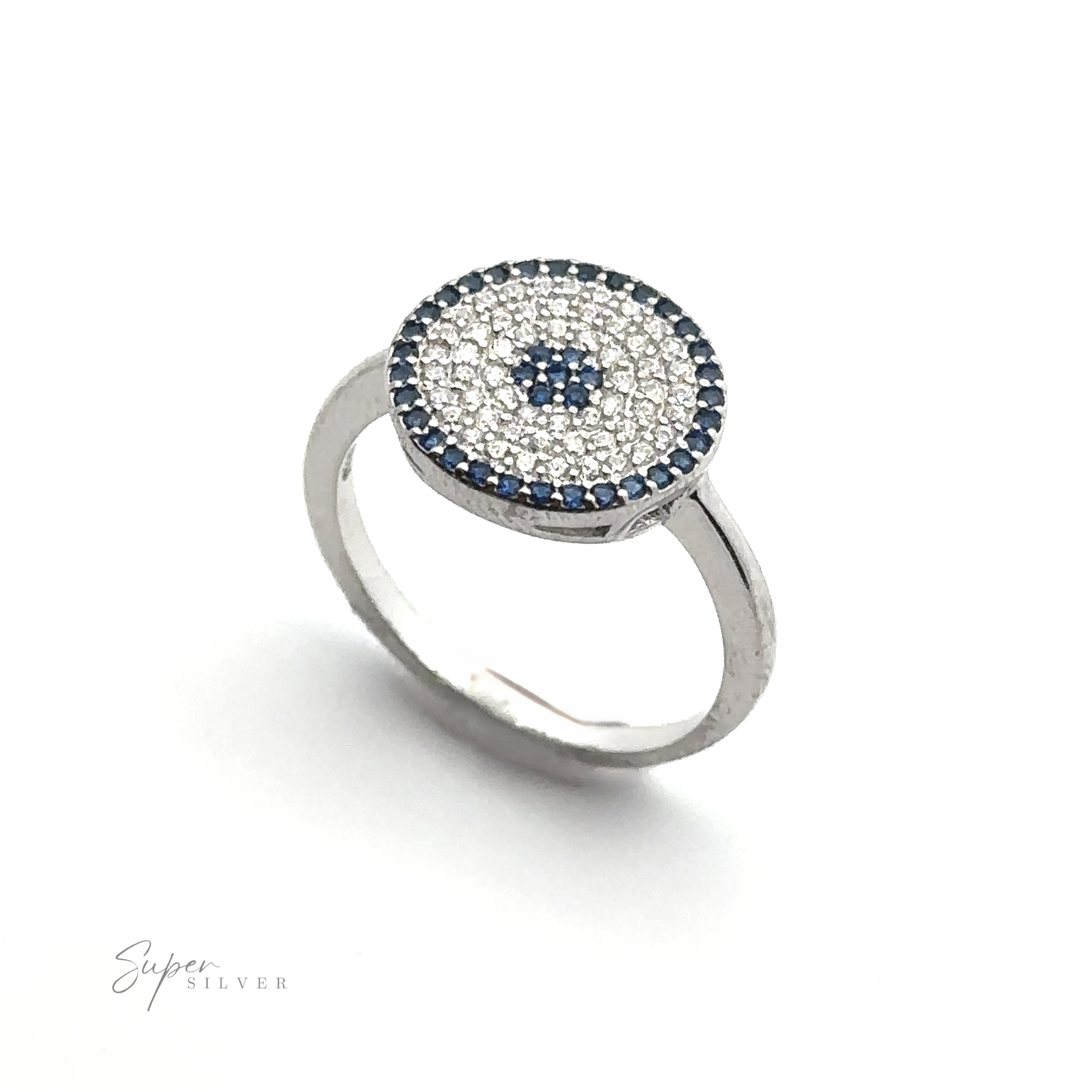 A Cubic Zirconia Evil Eye Ring with a round face, adorned with small white and blue gemstones arranged in concentric circles, creates an elegant evil eye ring design.