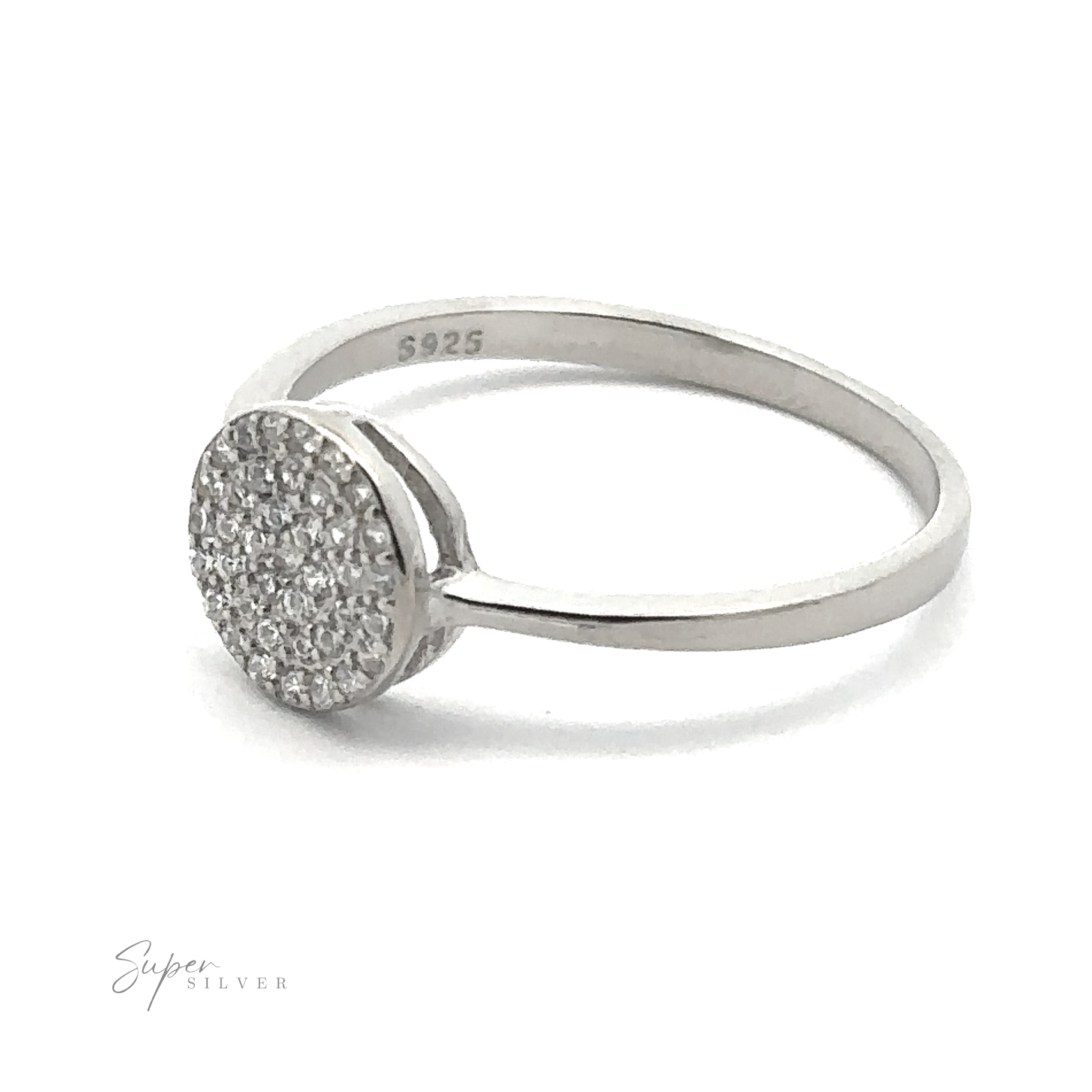 The Round Pave Cubic Zirconia Ring is a sterling silver piece featuring a circular head encrusted with small cubic zirconia stones and stamped with "S925." Set against a plain white background, the image accentuates the ring's intricate design. This exquisite ring boasts a rhodium finish that enhances its brilliance and durability.