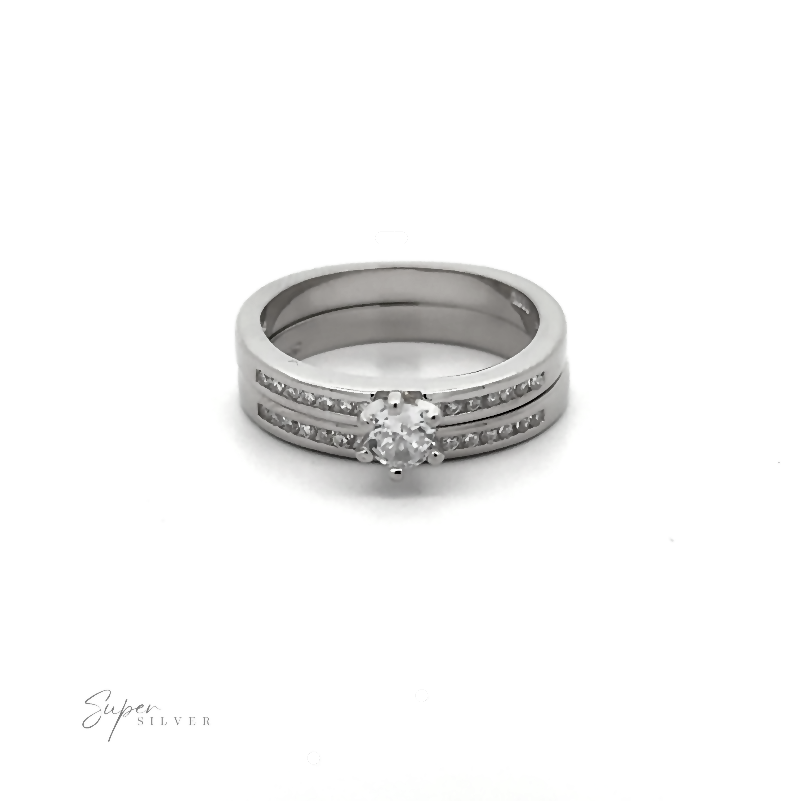 A Brilliant Round Cubic Zirconia Wedding Ring Set features a central round diamond with smaller cubic zirconia embedded along the band. The words "Super Silver" appear in the bottom left corner, highlighting its rhodium finish and elegance.