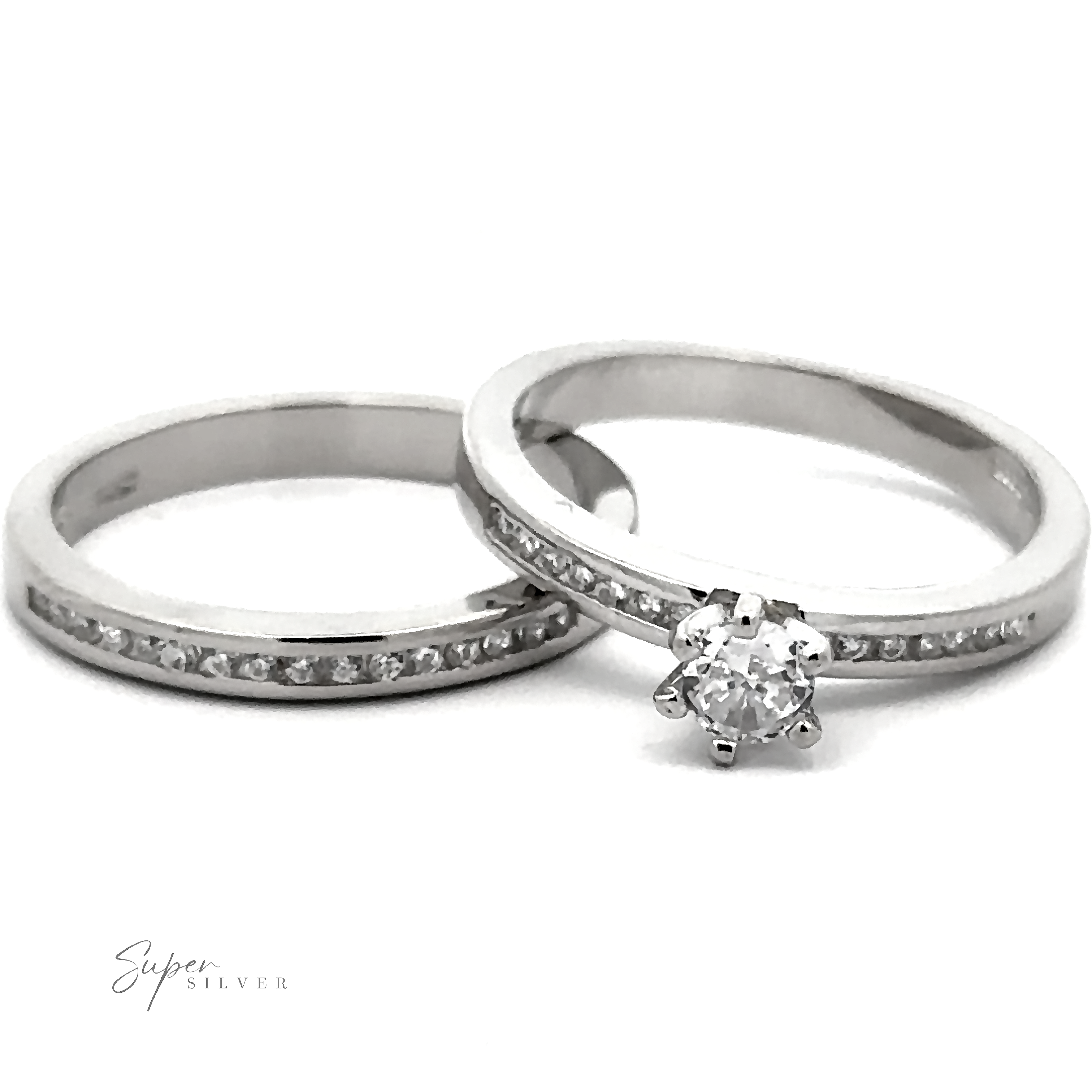 Two sterling silver rings: one with a solitaire diamond and the other, a round stone wedding band studded with Cubic Zirconia. Both rings are branded "Brilliant Round Cubic Zirconia Wedding Ring Set.