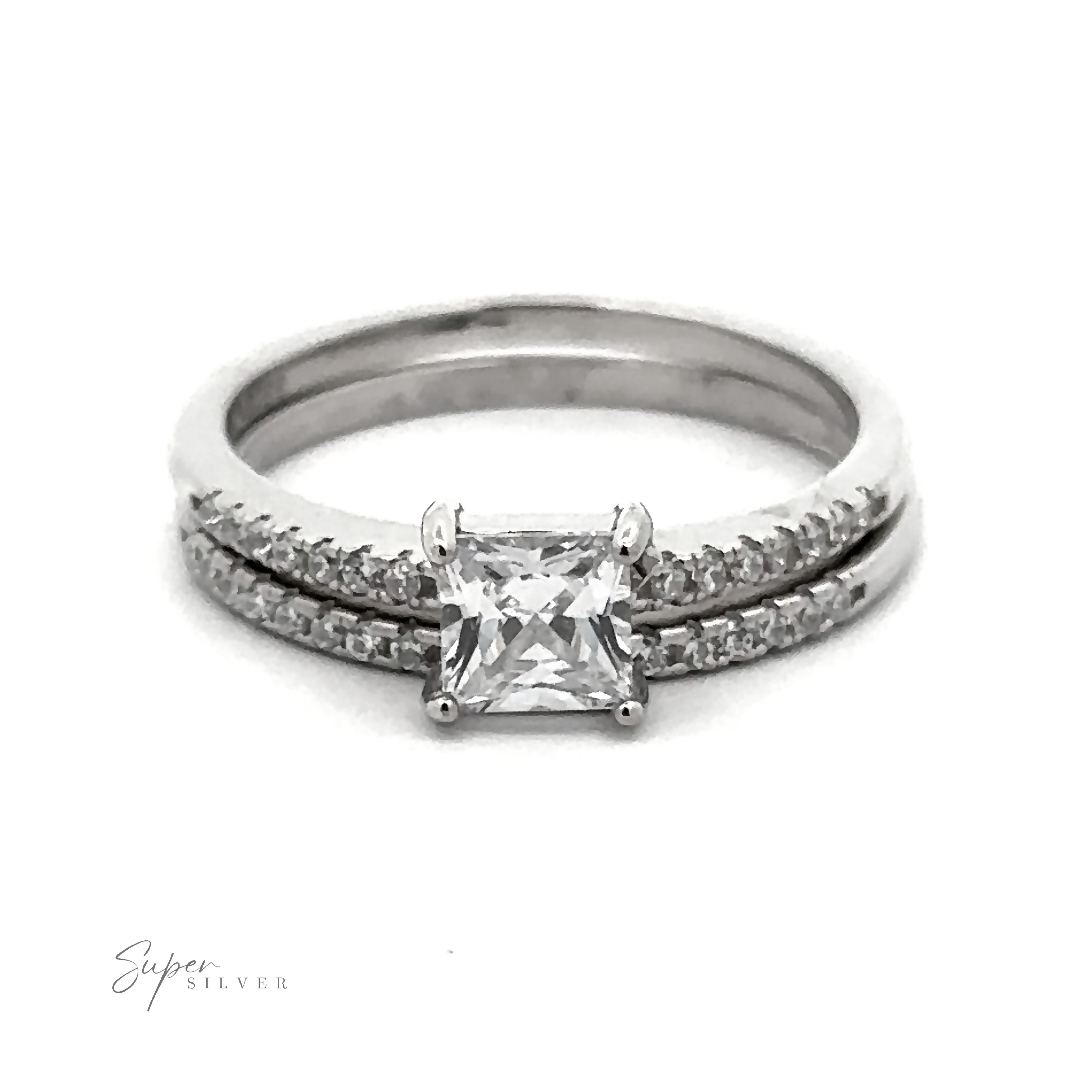 A stunning Princess Cut Cubic Zirconia Wedding Band Set featuring a square-cut central gemstone and a band adorned with small round stones, all complemented by a brilliant rhodium finish. The bottom right corner bears the logo "Super Silver.