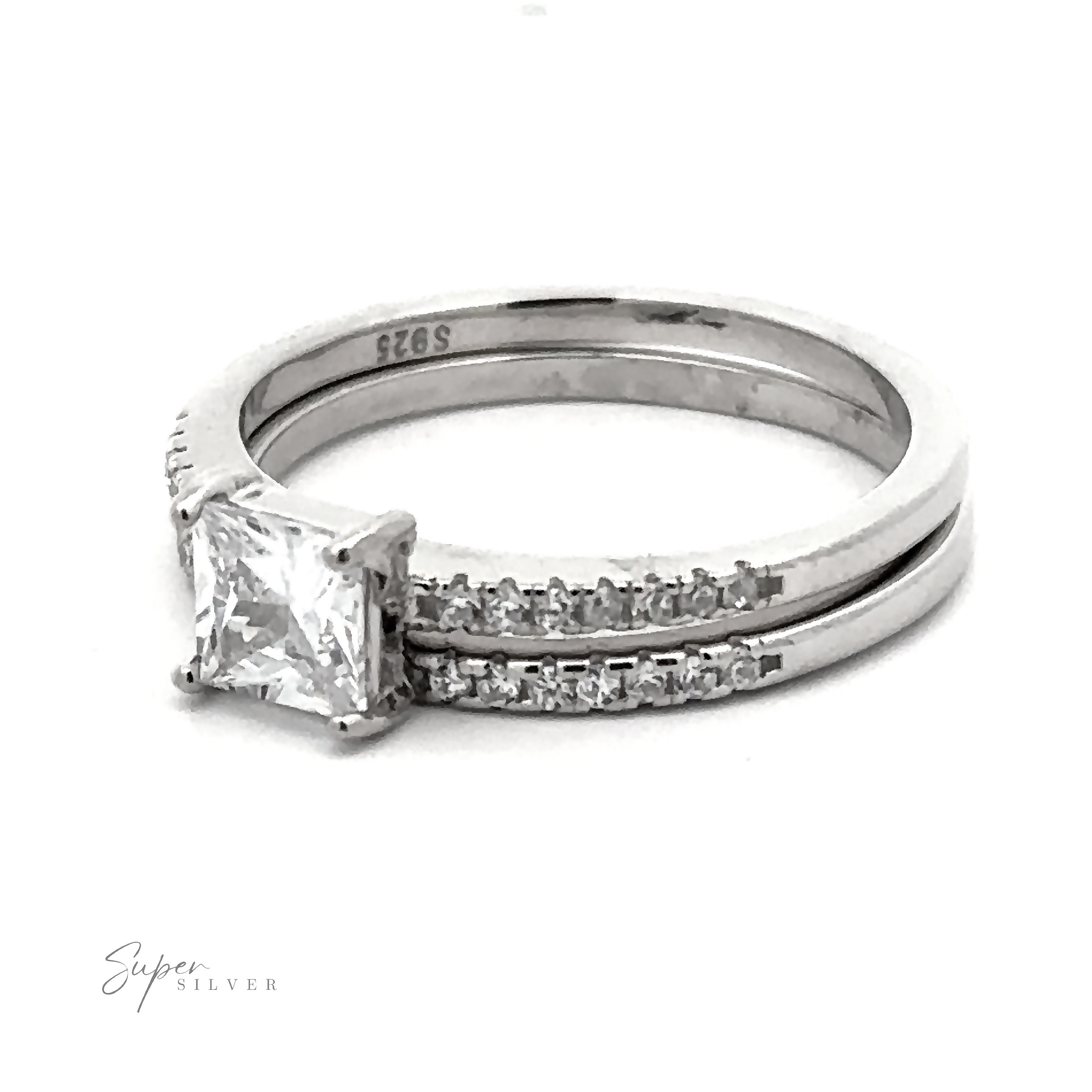 Princess Cut Cubic Zirconia Wedding Band Set featuring a princess cut cubic zirconia central stone and a band with smaller inset stones, all enhanced by a rhodium finish.