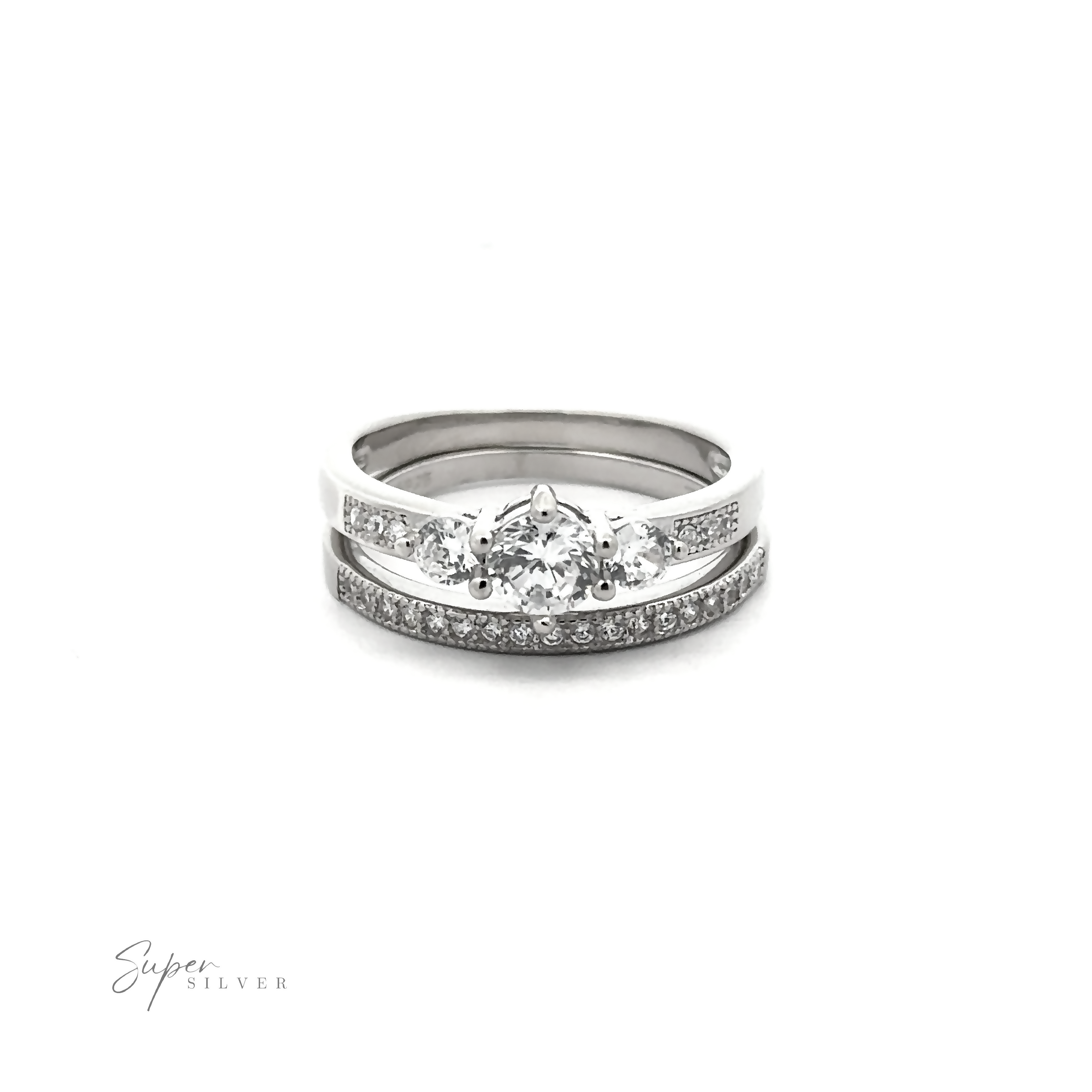 Discover the affordable Round Cubic Zirconia Wedding Band Set featuring a silver ring adorned with a central larger high-quality cubic zirconia stone and smaller stones on the band, complete with the "Super Silver" logo in the bottom left corner. Perfect for those seeking elegance without compromise.