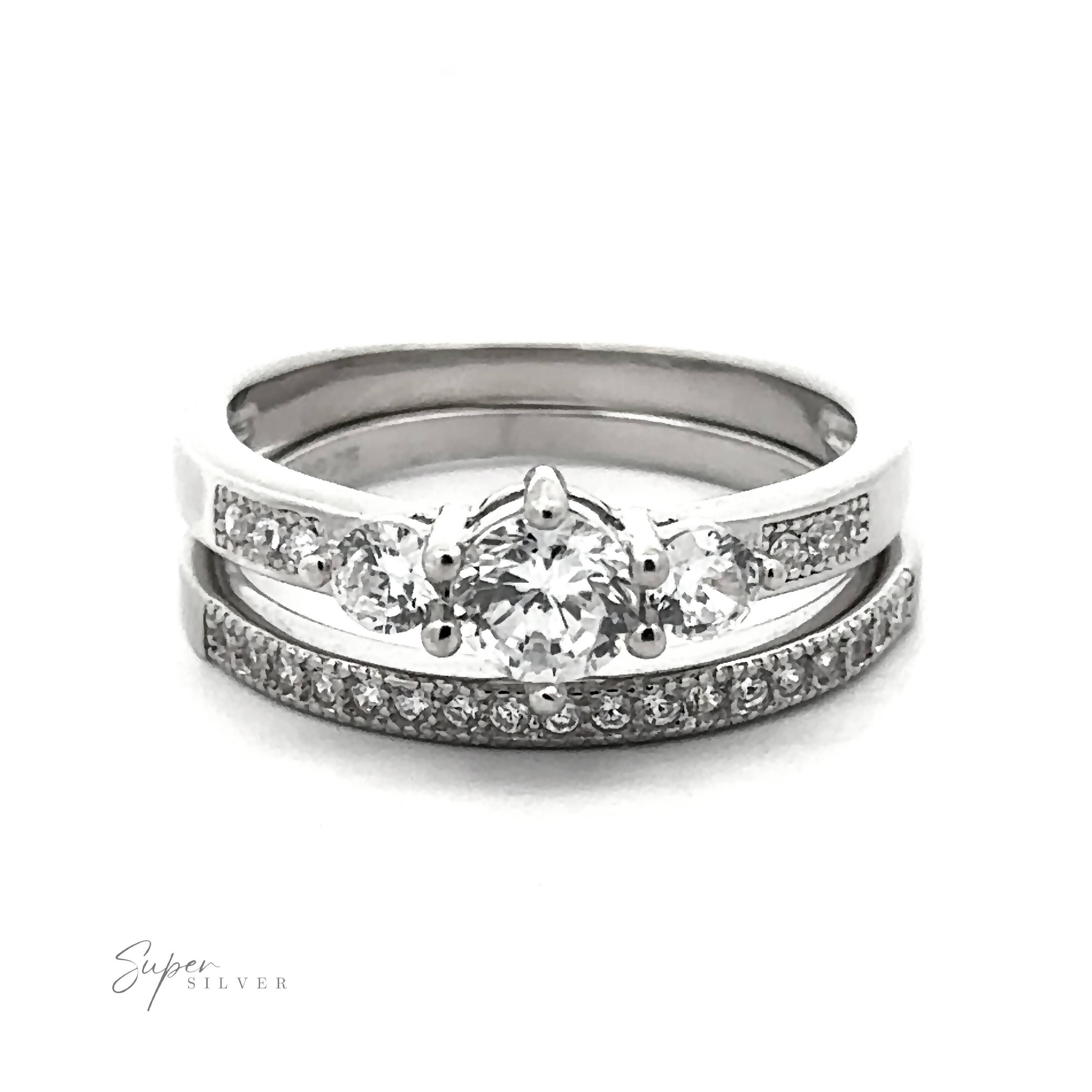 A Round Cubic Zirconia Wedding Band Set; the upper ring features three larger diamonds, and the lower ring is adorned with smaller high-quality cubic zirconia stones in a continuous line. This affordable wedding set offers elegance without compromise.
