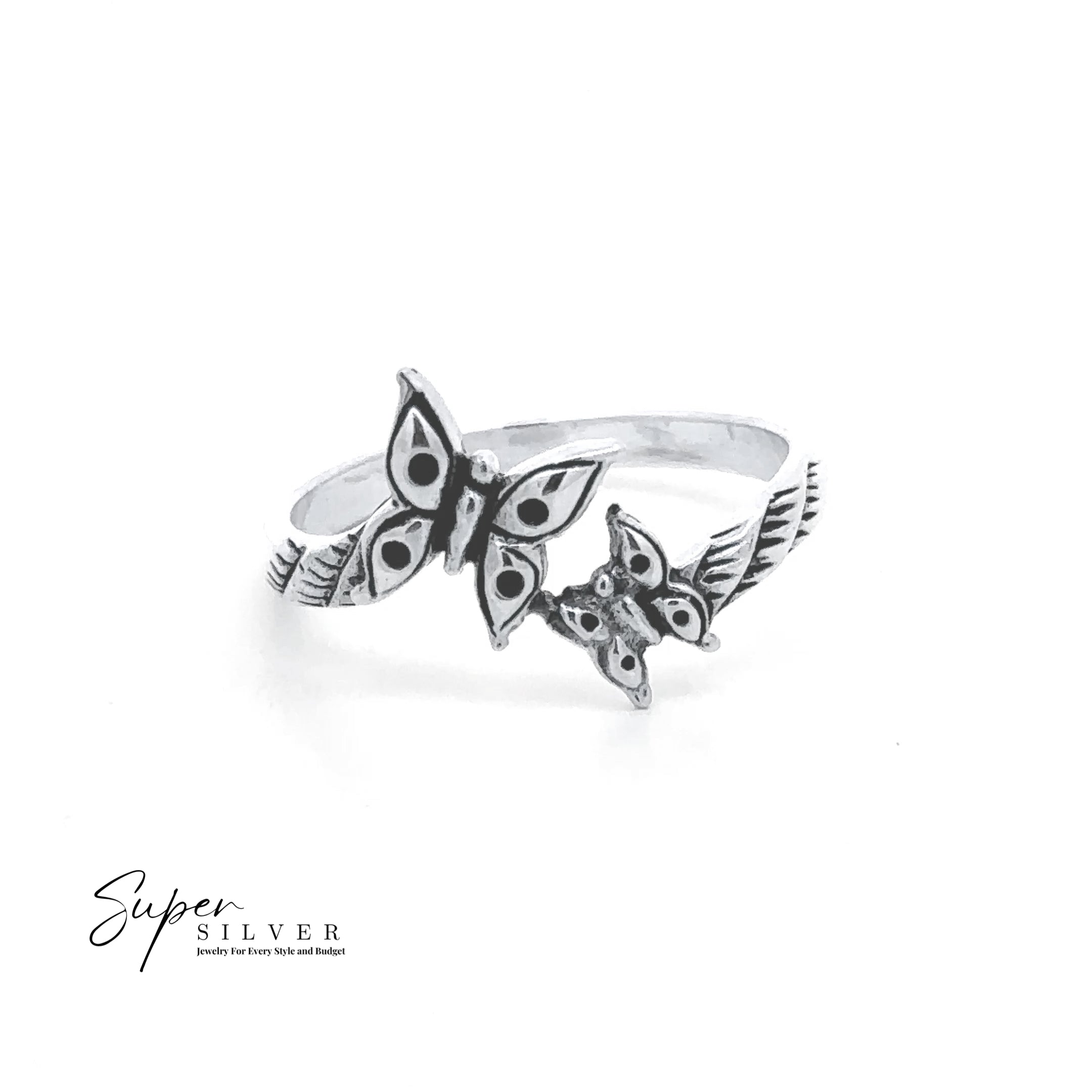 The Dainty Double Butterfly Ring, crafted in sterling silver with engraved feather accents, features two butterfly designs. Displayed on a white background, the piece includes subtle “Super Silver” branding in the corner.
