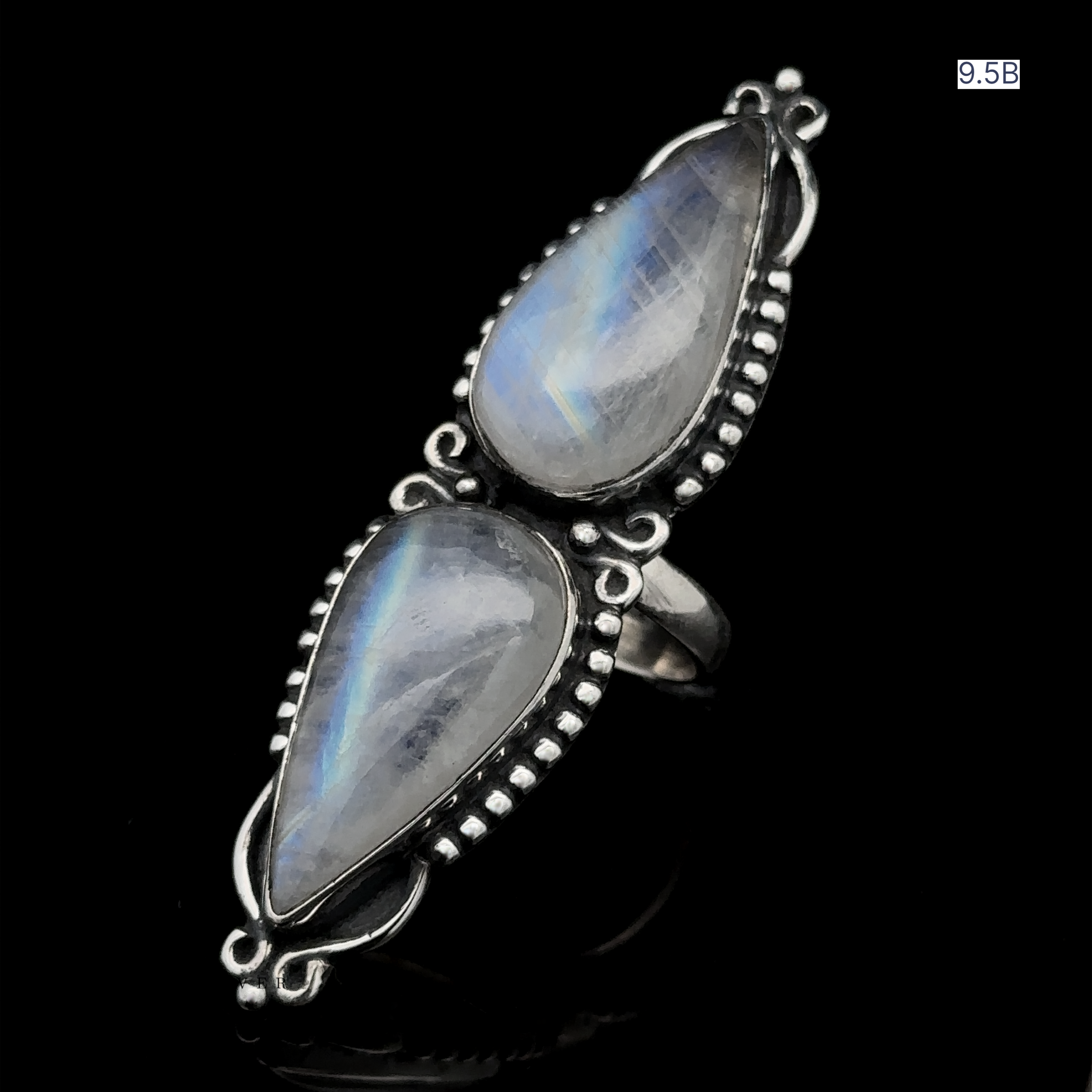 The Long Double Teardrop Moonstone Ring, made of sterling silver and showcasing two teardrop-shaped moonstone gemstones with intricate metalwork, is displayed on a black background with the size "9.5B" noted in the upper corner.