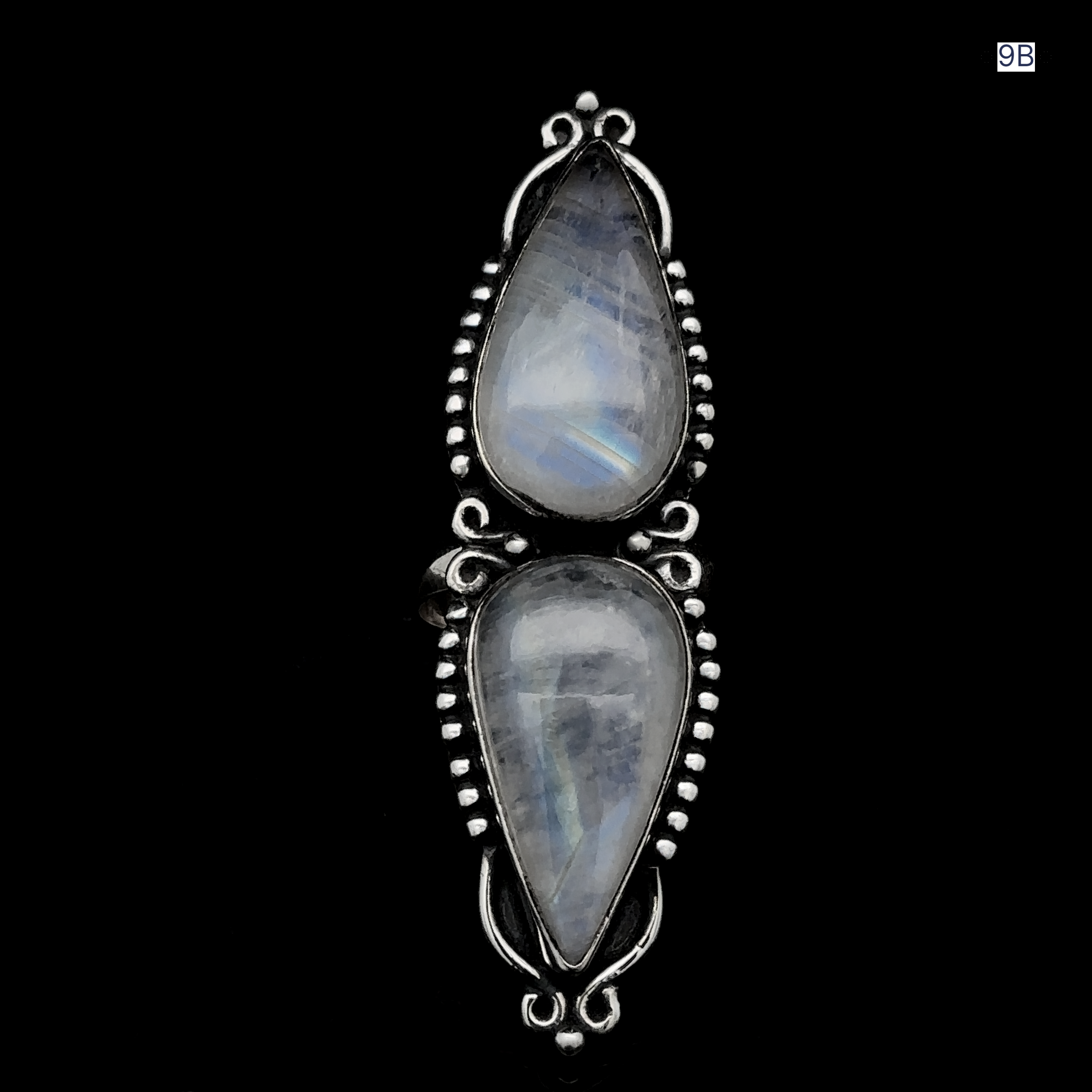Two teardrop-shaped moonstone gemstones set in an ornate sterling silver ring against a black background, making the Long Double Teardrop Moonstone Ring a stunning statement piece.