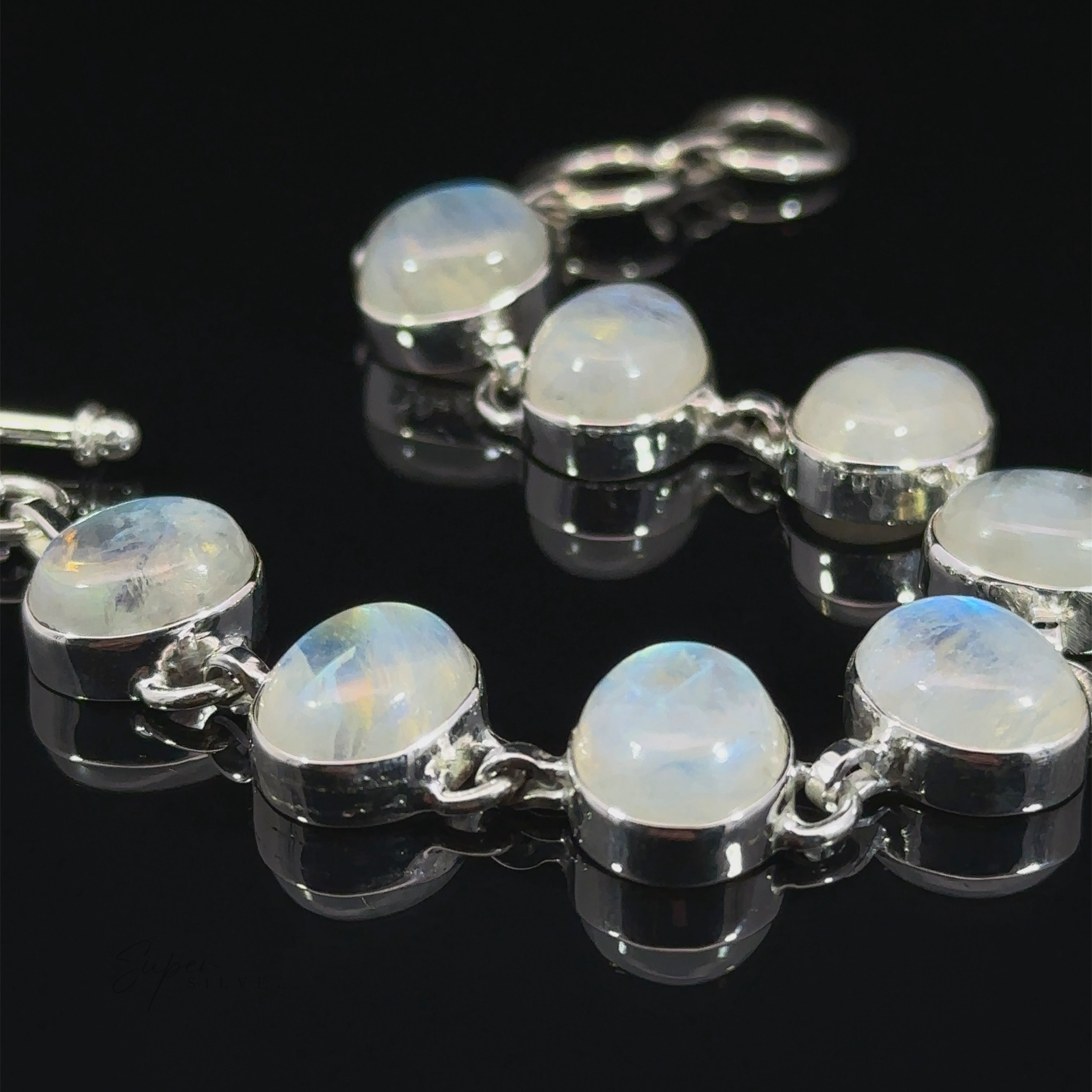 Statement Oval Gemstone Bracelets with round, polished labradorite stones set in linked metal casings, displayed against a dark background.
